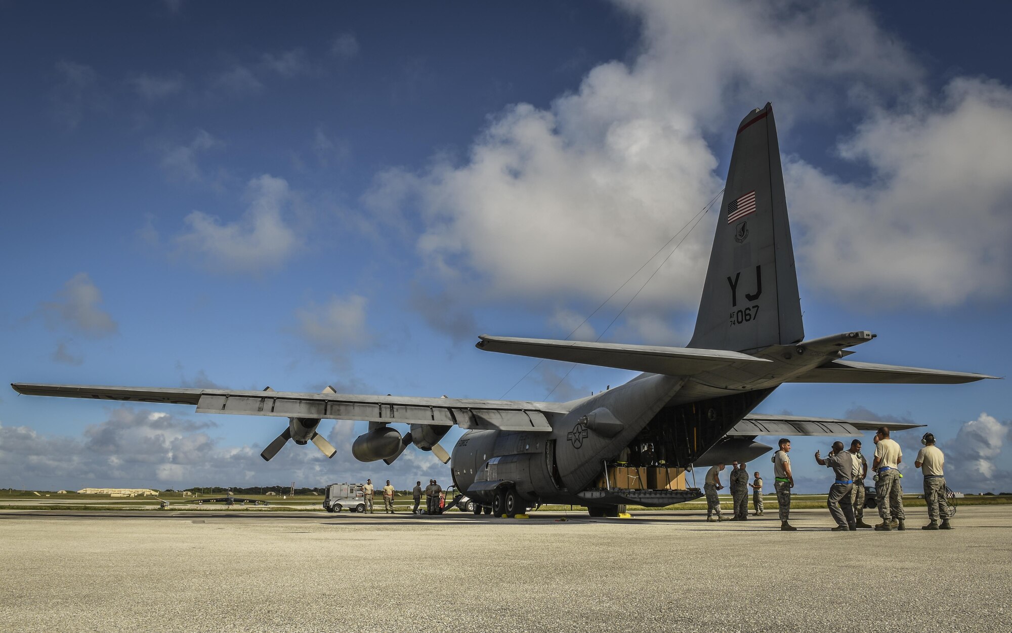 Members of the 374th Maintenance Group wait for a C-130H Hercules to takeoff during Operation Christmas Drop 2016 at Andersen Air Force Base, Guam, Dec. 9, 2016. This year marks the 65th year of OCD, which began in 1952, making it the world's longest-running airdrop mission. (U.S. Air Force photo by Senior Airman Elizabeth Baker)