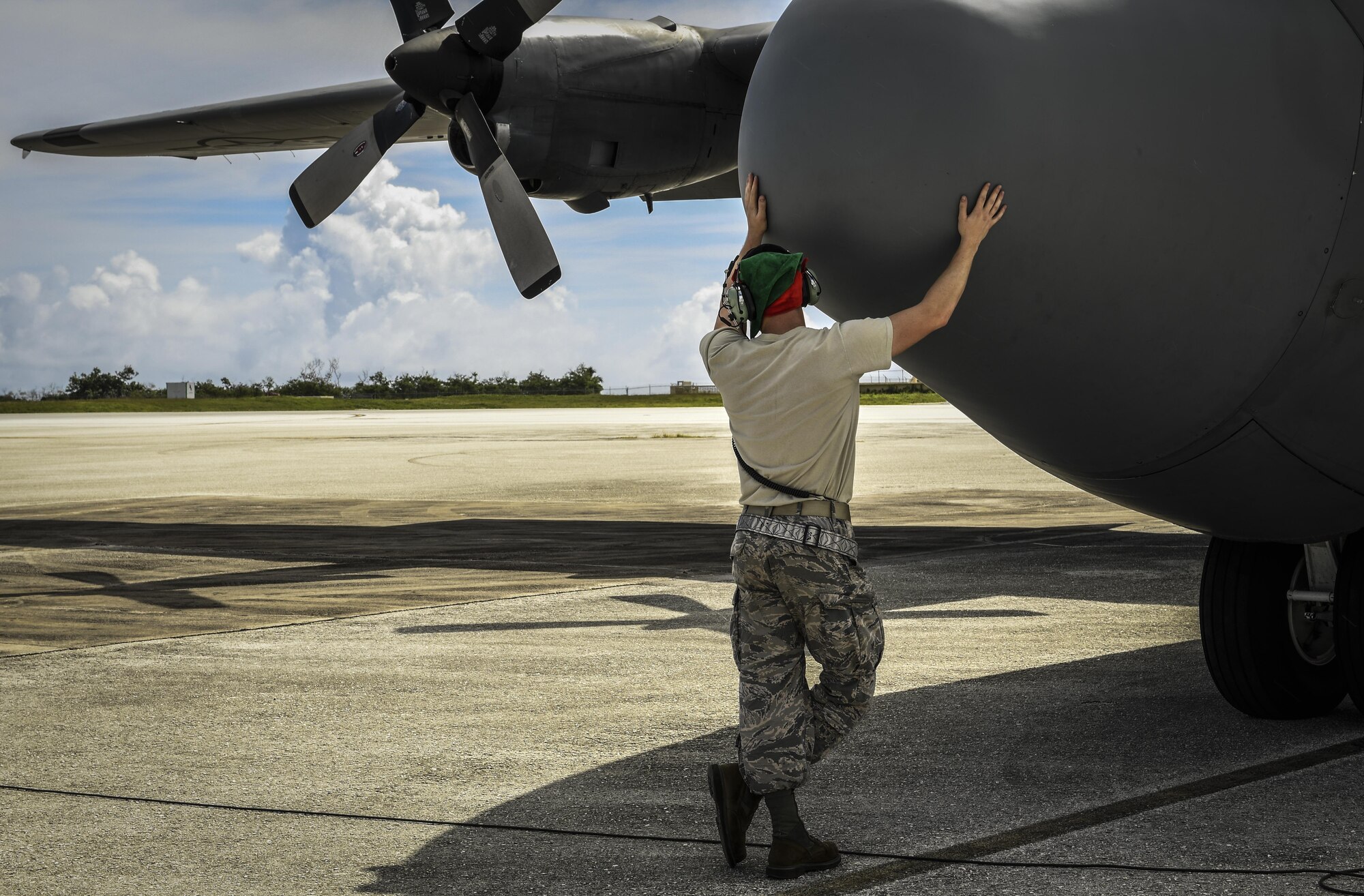 Senior Airman Benjamin Campanella, 374th Maintenance Group crew chief, pats a C-130H Hercules assigned to the 36th Airlift Squadron on the nose while awaiting takeoff during Operation Christmas Drop 2016 at Andersen Air Force Base, Guam, Dec. 10, 2016. This year marks 65 years of OCD, which provides joint airlift training opportunities for both peace and wartime efforts. (U.S. Air Force photo by Senior Airman Elizabeth Baker)