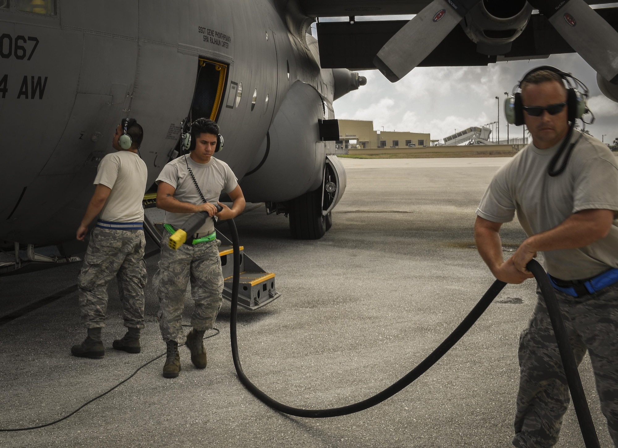 Senior Airman John Huerta, 374th Aircraft Maintenance Squadron communications and navigation systems journeyman, and Tech Sgt. Ross Mcquiggan, 374 AMXS aerospace maintenance craftsman, retract a power cable from a C-130H Hercules in preparation for takeoff during Operation Christmas Drop 2016 at Andersen Air Force Base, Guam, Dec. 10, 2016. Operation Christmas Drop highlights the U.S. and allied airpower capabilities to orient and respond to activities in peacetime and crisis. (U.S. Air Force photo by Senior Airman Elizabeth Baker)