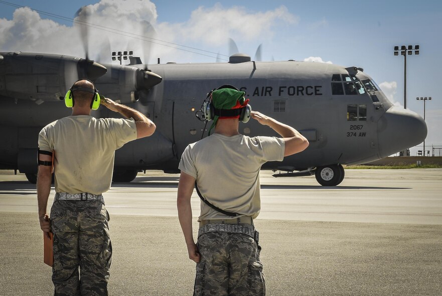 Staff Sgt. Solomon Faulkner, 374th Maintenance Squadron aerospace ground equipment craftsman, and Senior Airman Benjamin Campanella, 374th Maintenance Group crew chief, salute a C-130H Hercules assigned to the 36th Airlift Squadron before takeoff during Operation Christmas Drop at Andersen Air Force Base, Guam, Dec. 10, 2016. Each year OCD provides aid to over 30,000 islanders in Chuuk, Palau, Yap, Marshall Islands and the Commonwealth of the Northern Mariana Islands. (U.S. Air Force photo by Senior Airman Elizabeth Baker)