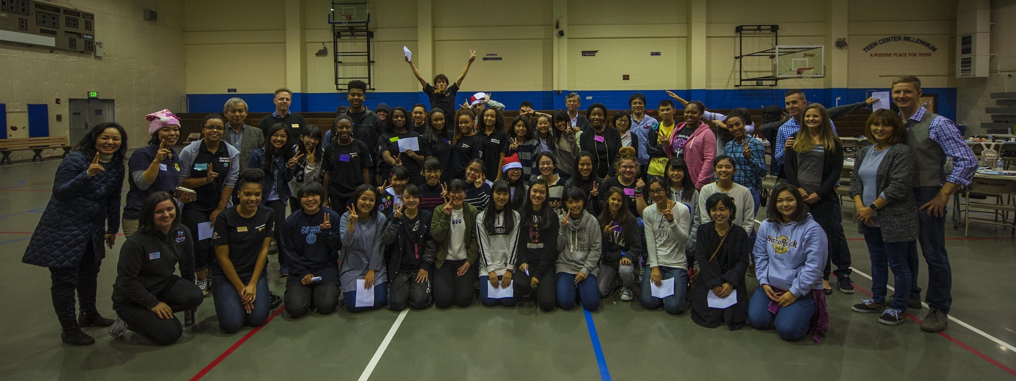 Okinawan and American schoolchildren, along with volunteers from the two communities, take part in a community event meant to build new relationships for the students and to provide insight into another culture, Dec. 17, 2016, at the teen center on Kadena Air Base, Japan. The event included food, games, holiday lights and a song sung in both Japanese and English. (U.S. Air Force photo by Airman 1st Class Nick Emerick/Released)
