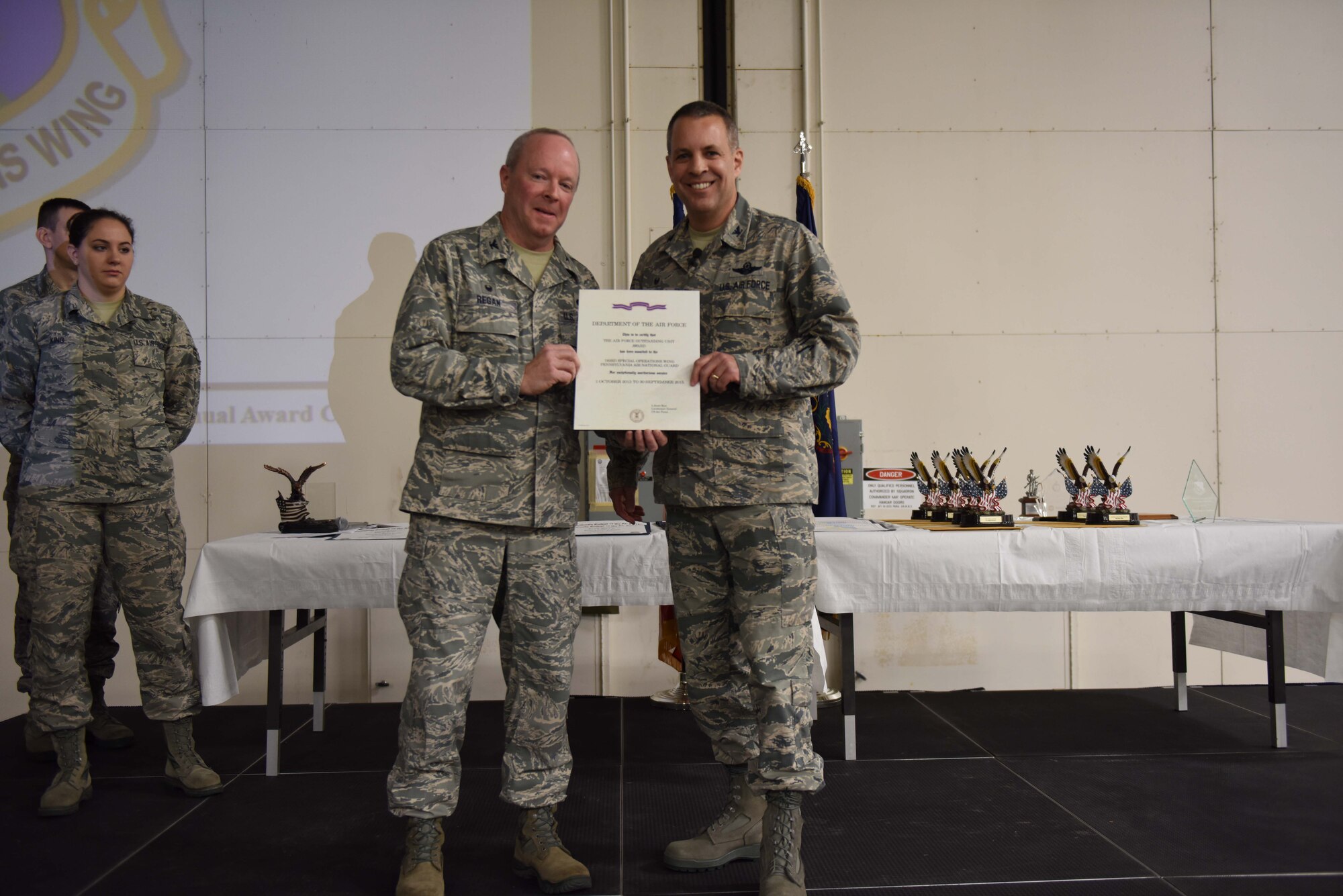 Col. Mike Cason (right), Commander of the 193rd Special Operations Wing, Middletown, Pennsylvania, receives the Outstanding Unit Award, Dec. 18, from Col. Mike Regan, Deputy Adjutant General - Air, during the wing’s annual awards ceremony. This unit award makes it the 17th for the 193rd SOW (U.S. Air National Guard photo by Senior Airman Ethan Carl/Released)