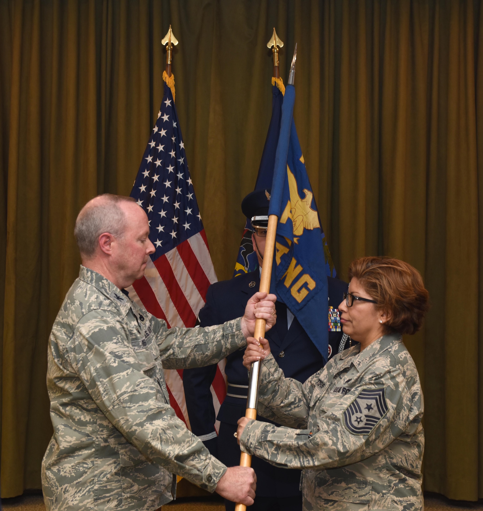 State Command Chief Master Sgt. Regina Stoltzfus receives the guidon from Col. Mike Regan, Commander, Pennsylvania Air National Guard, as she accepts responsibility as the ninth state command chief master sergeant. The passing of the guidon signifies the passing of the responsibility for all PA ANG enlisted personnel. (U.S. Air National Guard Photo by Tech. Sgt. Claire Behney/Released)