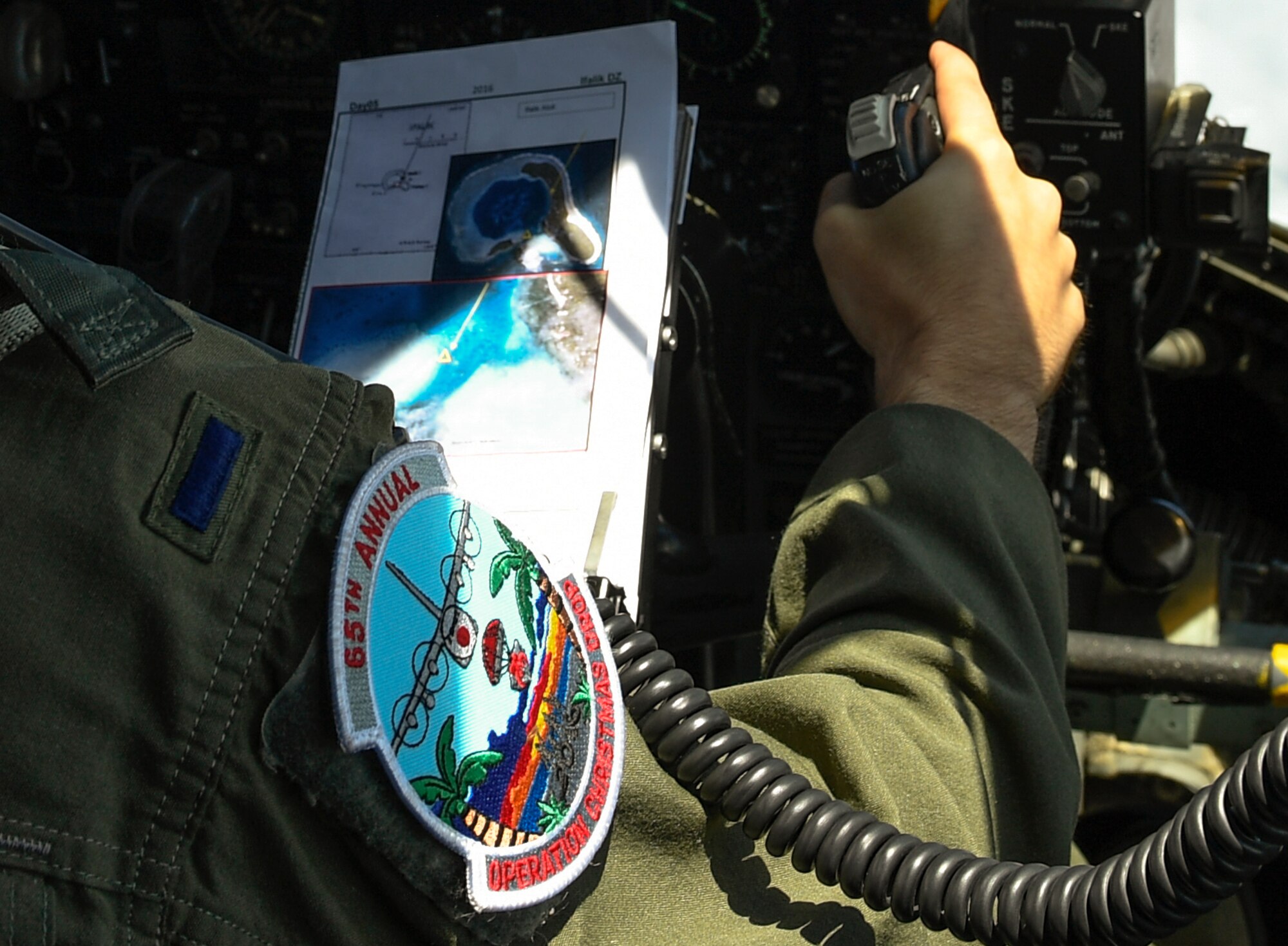 1st Lt. Chad Moore, 36th Airlift Squadron pilot, flies a C-130H Hercules over the Pacific islands during Operation Christmas Drop, Dec. 11, 2016. The aircrew dropped bundles of food, supplies and gifts over the Micronesian Islands. Each year OCD provides aid to over 30,000 islanders in Chuuk, Palau, Yap, Marshall Islands and the Commonwealth of the Northern Mariana Islands. (U.S. Air Force photo by Senior Airman Elizabeth Baker)