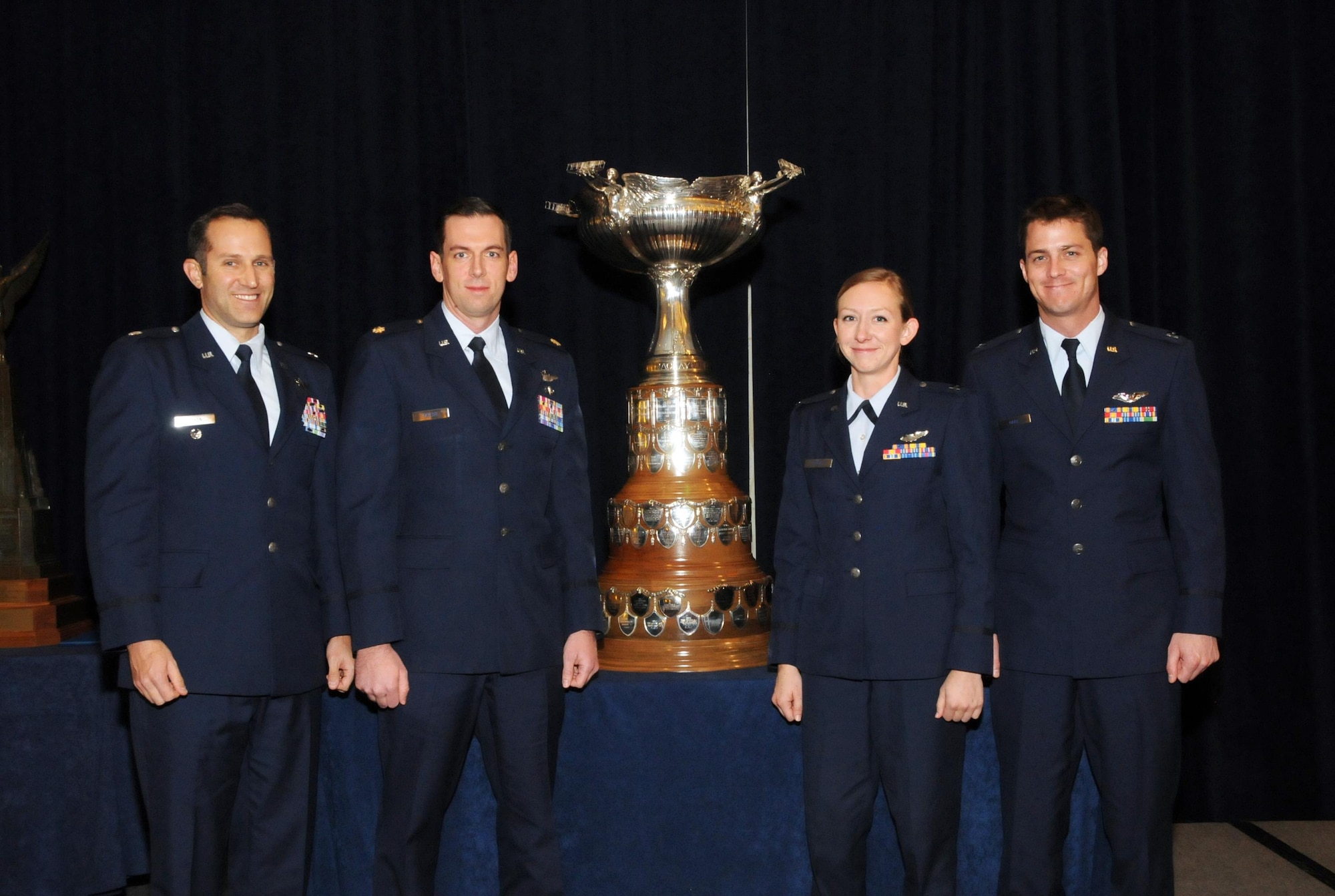 (From left) U.S. Air Force Lt. Col. Jeffrey Cohen, Maj. Seth Taylor, Capt. Danielle Kangas and Capt. Mathew Park are awarded the 2015 Mackay Trophy during the National Aeronautic Association fall awards ceremony in Arlington, Virginia, Dec. 8, 2016. The trophy is awarded for the “most meritorious flight of the year by an Air Force person, persons, or organization.” Cohen, Taylor, Kangas and Park earned the trophy by providing air support during a firefight in Hassekah, Syria between friendly Kurdish ground units and Islamic State enemy personnel. Their dedication, professionalism, bravery and airmanship ended a three-month operations in Northern Syria and resulted in the friendly Kurdish retaking 17 thousand squadron kilometers of territory and securing the Syria and Turkey boarder between Iraq and the Euphrates River. Cohen is now assigned to the Air Combat Control Inspector General team at Joint Base Langley-Eustis, Virginia, and Kangas is now a part of the 64th Aggressor Squadron at Nellis Air Force Base, Nevada. (Courtesy Photo)