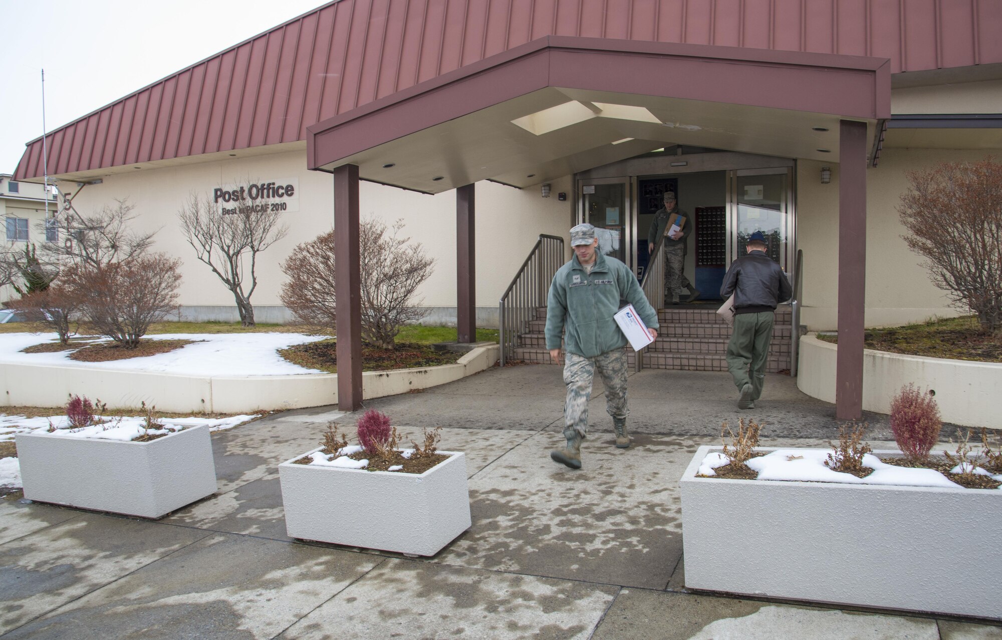 U.S Air Force Senior Airman Edwin Cajigas-Olavarria, the 35th Maintenance Operations Squadron munitions inspector, walks away from a post office at Misawa Air Base, Japan, Dec. 15, 2016. Misawa’s post office receives three trucks daily with a multitude of packages and mail from all over the world. Once everything is unloaded, approximately 20 Airmen sort and scan items into their system. (U.S. Air Force photo by Airman 1st Class Sadie Colbert)