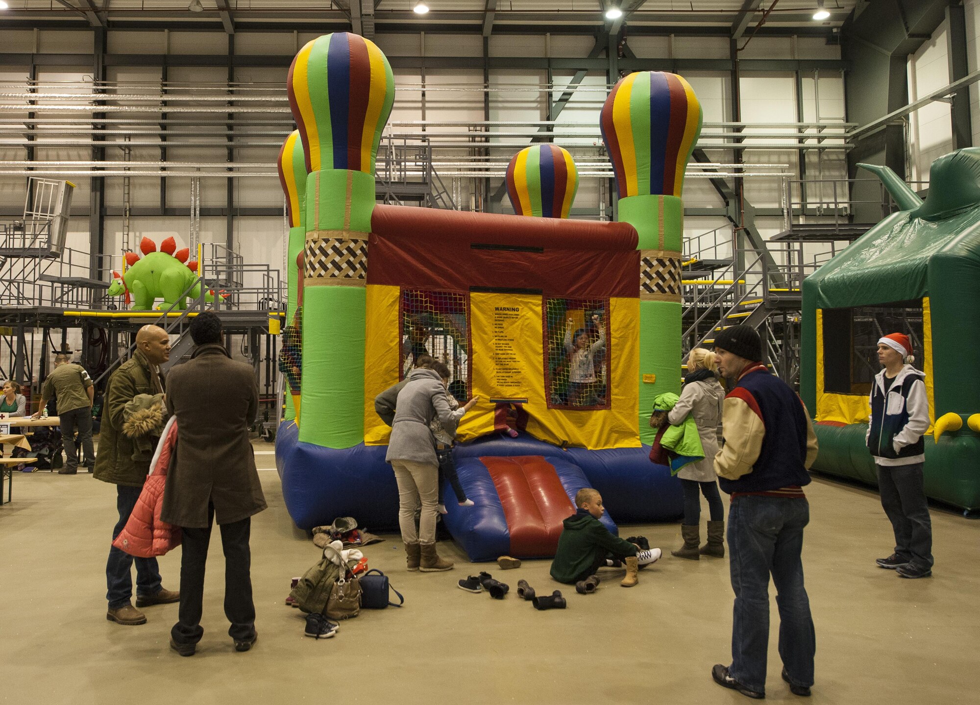 Kids play in a bounce house during a Christmas event held at Ramstein Air Base, Germany, Dec. 16, 2016. Children played in jumping castles and everyone participated in penguin bowling, face painting, a photo booth and watched movies. (U.S. Air Force photo by Airman 1st Class Lane T. Plummer)
