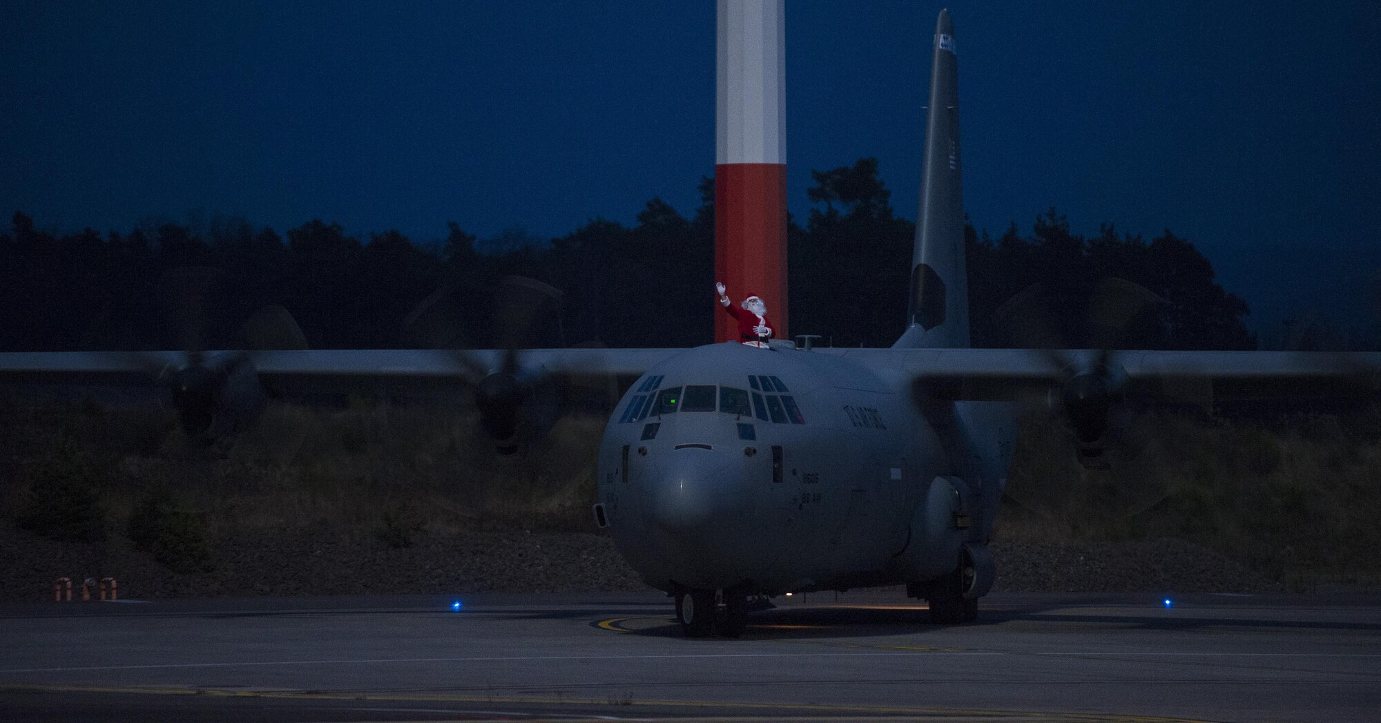 Santa Claus waves as the C-130J Super Hercules he’s riding arrives at a Christmas event held at Ramstein Air Base, Germany, Dec. 16, 2016. Santa opened a workshop at the Dual-Bay Complex here and invited families across the community to participate in holiday festivities. (U.S. Air Force photo by Airman 1st Class Lane T. Plummer)