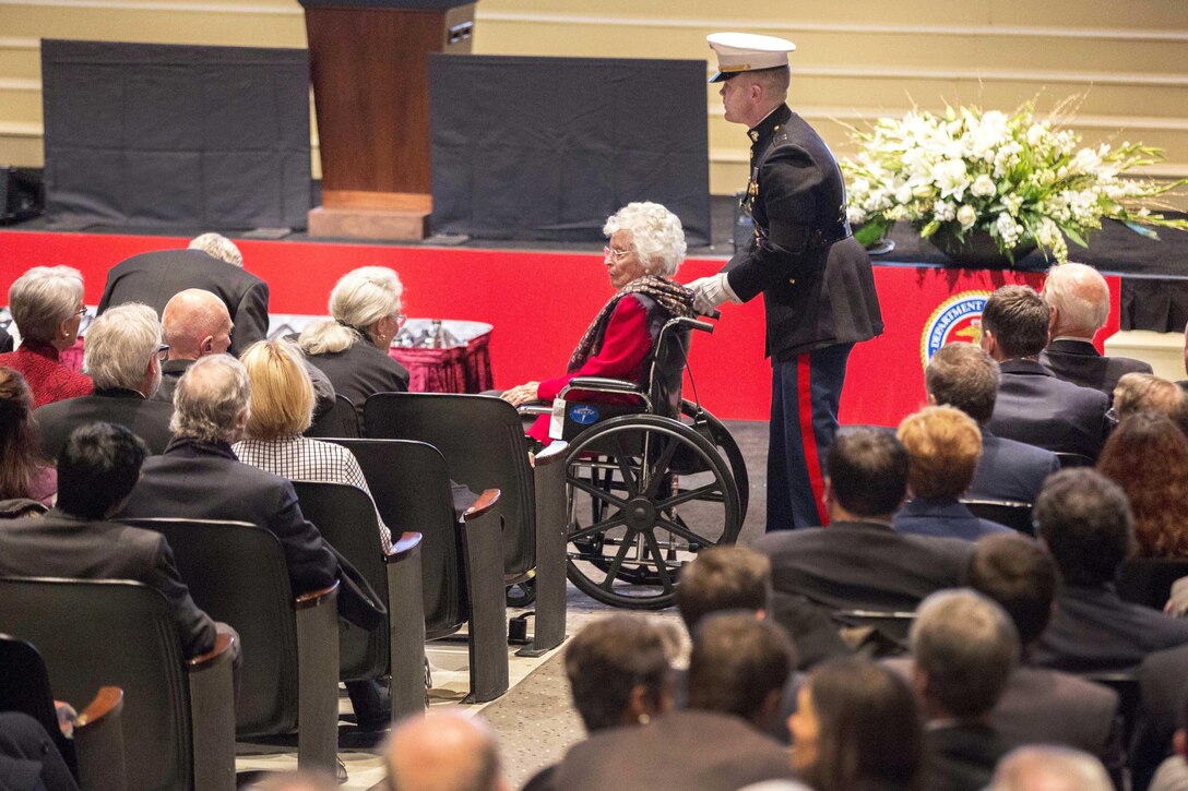A Marine escorts Annie Glenn during a celebration of the life of her late husband, John Glenn, at the Ohio State University in Columbus, Dec. 17, 2016. Marine Corps photo by Lance Cpl. Daisha R. Sosa