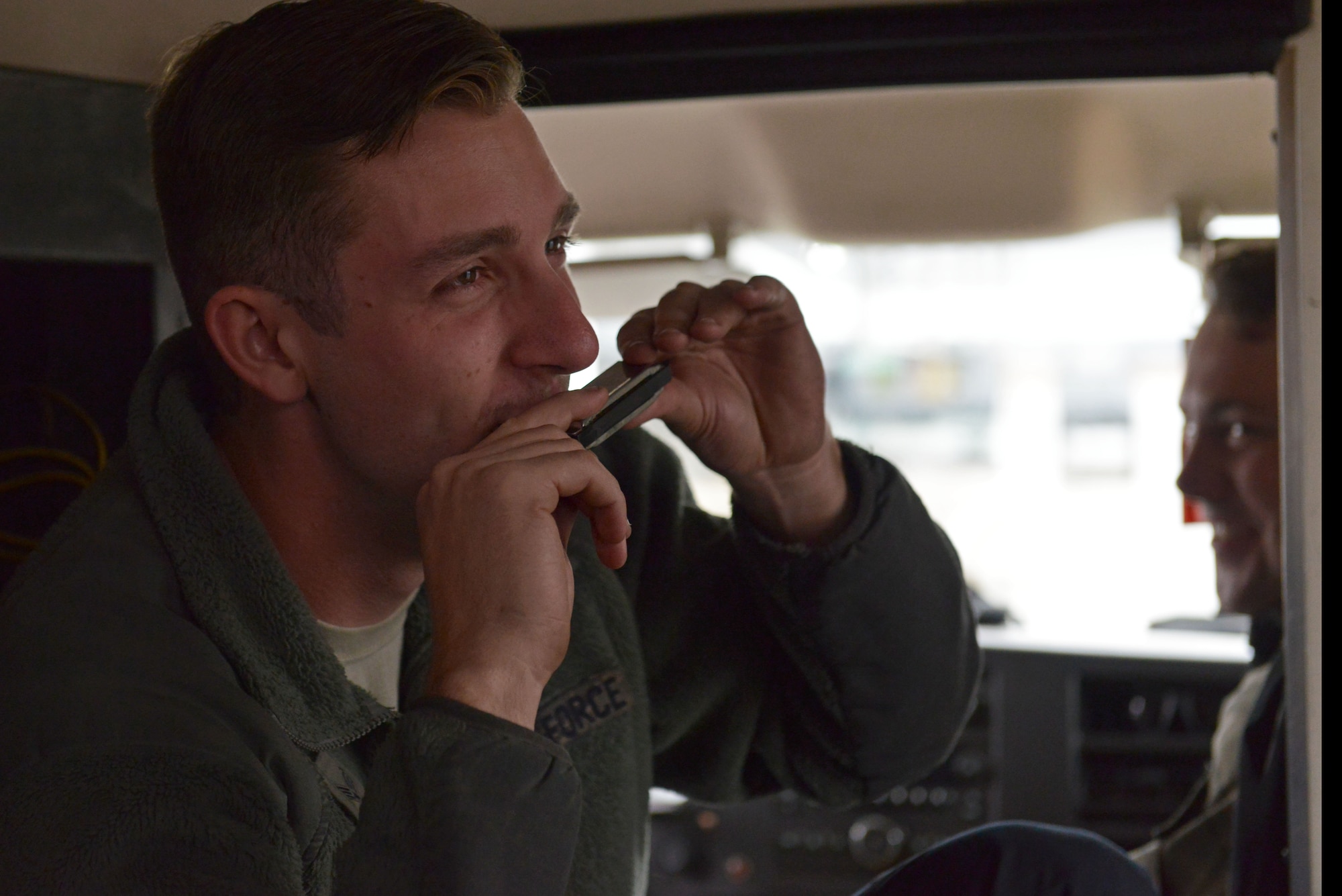 U.S. Air Force Senior Airman Zachary Jung, 20th Aircraft Maintenance Squadron tactical aircraft maintainer, plays the harmonica while in an expediter truck at Shaw Air Force Base, S.C., Dec. 13, 2016. Expediter trucks, also known as “bread trucks”, are commonly used to transport Airmen to various locations on the flightline. (U.S. Air Force photo by Airman 1st Class Destinee Sweeney)