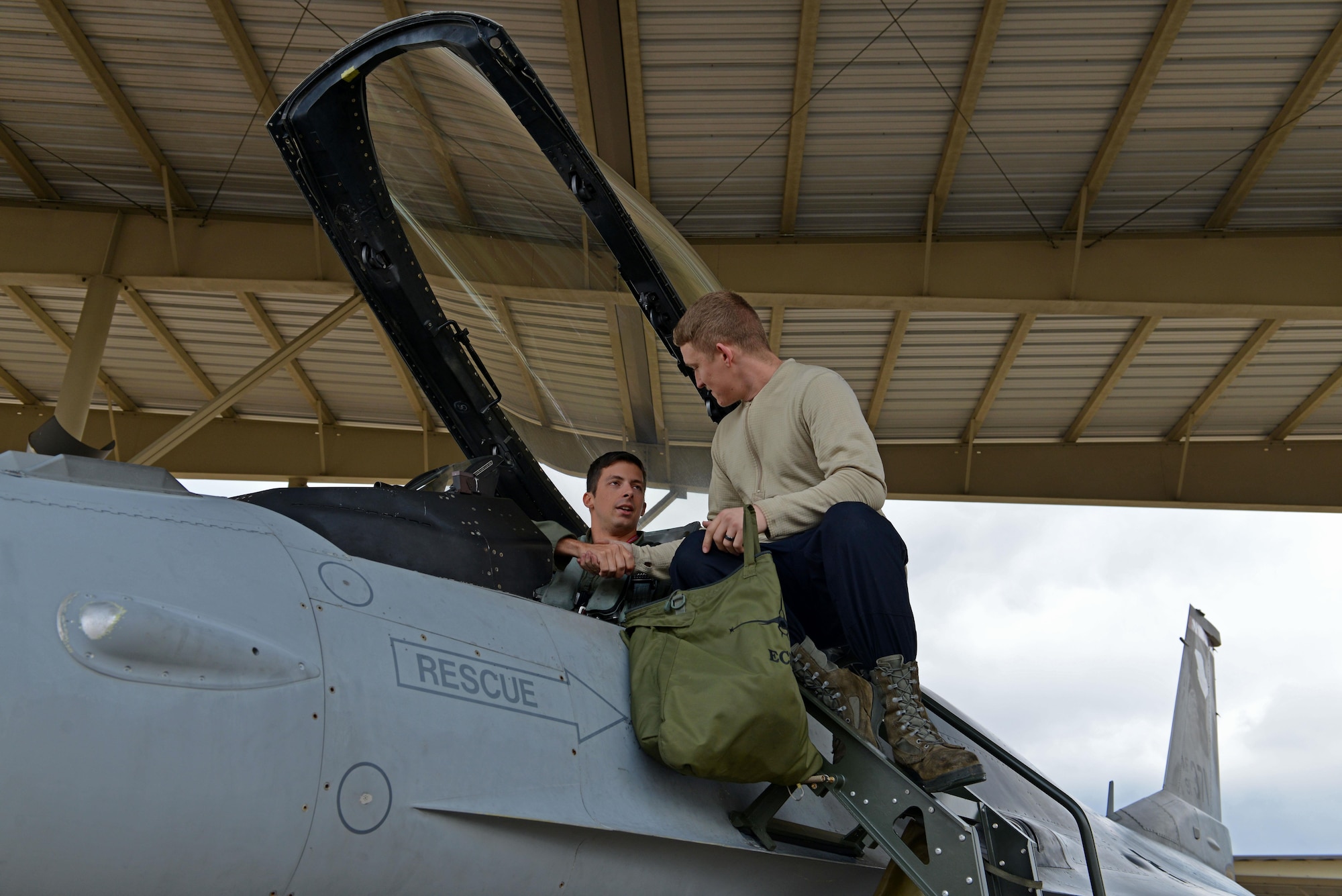 U.S. Air Force Capt. Michael Arnold, 77th Fighter Squadron pilot, shakes hands with Senior Airman Zachary Jinkins, 20th Aircraft Maintenance Squadron tactical aircraft maintainer, at Shaw Air Force Base, S.C., Dec. 14, 2016. Each F-16CM Fighting Falcon is assigned two tactical aircraft maintainers responsible for the aircraft, who are designated as the dedicated crew chief and the assistant dedicated crew chief. Tactical aircraft maintainers are often referred to as crew chiefs. (U.S. Air Force photo by Airman 1st Class Destinee Sweeney)