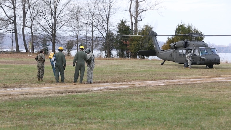 Marines with Logistics Platoon, Chemical Biological Incident Response Force, CBIRF, speak to an Army pilot of An UH-60 Blackhawk helicopter assigned to 12th Aviation Battalion, U.S. Army, prior to a sling load operation as part of Initial Reaction Force B certification exercise, CERTEX, aboard Naval Support Facility Indian Head Annex Stump Neck, Md., Dec. 13, 2016. This CERTEX evaluated all sections composing the IRF including identification and detection, technical rescue, decontamination, search and rescue/casualty extraction, medical, explosive ordnance disposal, as well as command and control.  (Official U.S. Marine Corps photo by Staff Sgt. Santiago G. Colon Jr./RELEASED)
