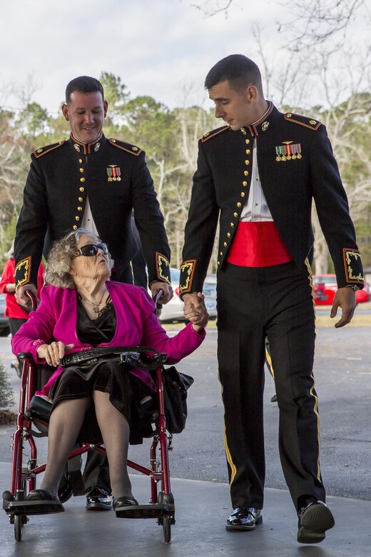 Two officers escort a guest during the Marine Corps Air Station Beaufort Officers’ Spouses’ Club’s senior citizen’s tea aboard MCAS Beaufort, Dec. 11. MCAS Beaufort holds the annual event to honor and serve the senior citizens of the Beaufort area. This year marked the 47th  year of the annual tea. Many of the senior citizens who attended are former service members or spouses of former service members.