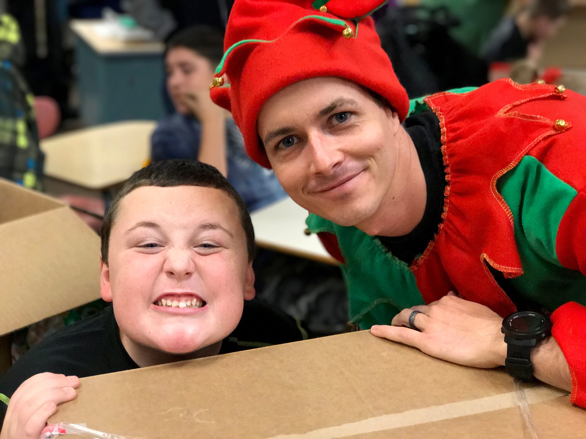 1st Lt. Cory Bobo, 67th Aerial Port Squadron, has a photo moment with Mound Fort Junior High student Zack during a Christmas party for students with special needs. The 67th APS has hosted the party annually for nearly 30 years, providing gifts, clothes, and hygiene items. (Courtesy photo) 