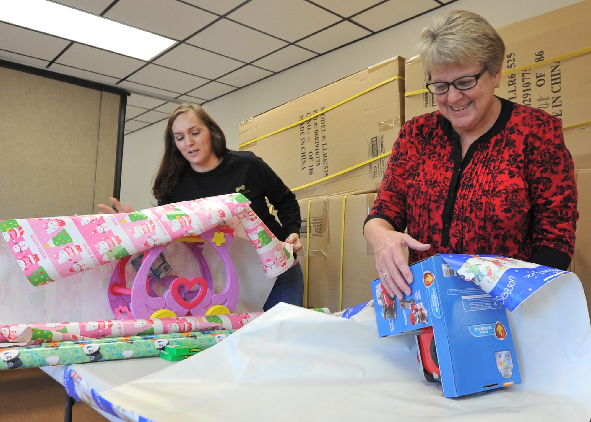 (From left to right) Mandy Dixon, Tyndall Chapel accounting manager, and Lisa Morris, Tyndall Chapel center volunteer, prepare gifts during Operation Angel Tree at the Tyndall Air Force Base Chapel Dec. 16, 2016. This event is one of several hosted by multiple Tyndall community organizations every year during the holiday season. Each of these events are focused on embracing camaraderie within the community. (U.S. Air Force photo by Senior Airman Ty-Rico Lea/Released)