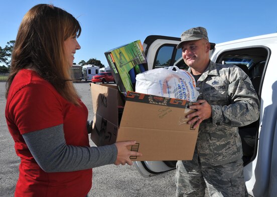 Aimee Bright, Tyndall Spouses Club president, helps Master Sgt. Kevin Marshall, 43d Aircraft Maintenance Unit specialist section chief, load donated gifts into a vehicle for delivery during Operation Angel Tree at the base Thrift Shop on Tyndall Air Force Base, Fla., Dec. 16, 2016. The event mainly focuses to help single income and larger families during the holiday season. (U.S. Air Force photo by Senior Airman Ty-Rico Lea/Released)