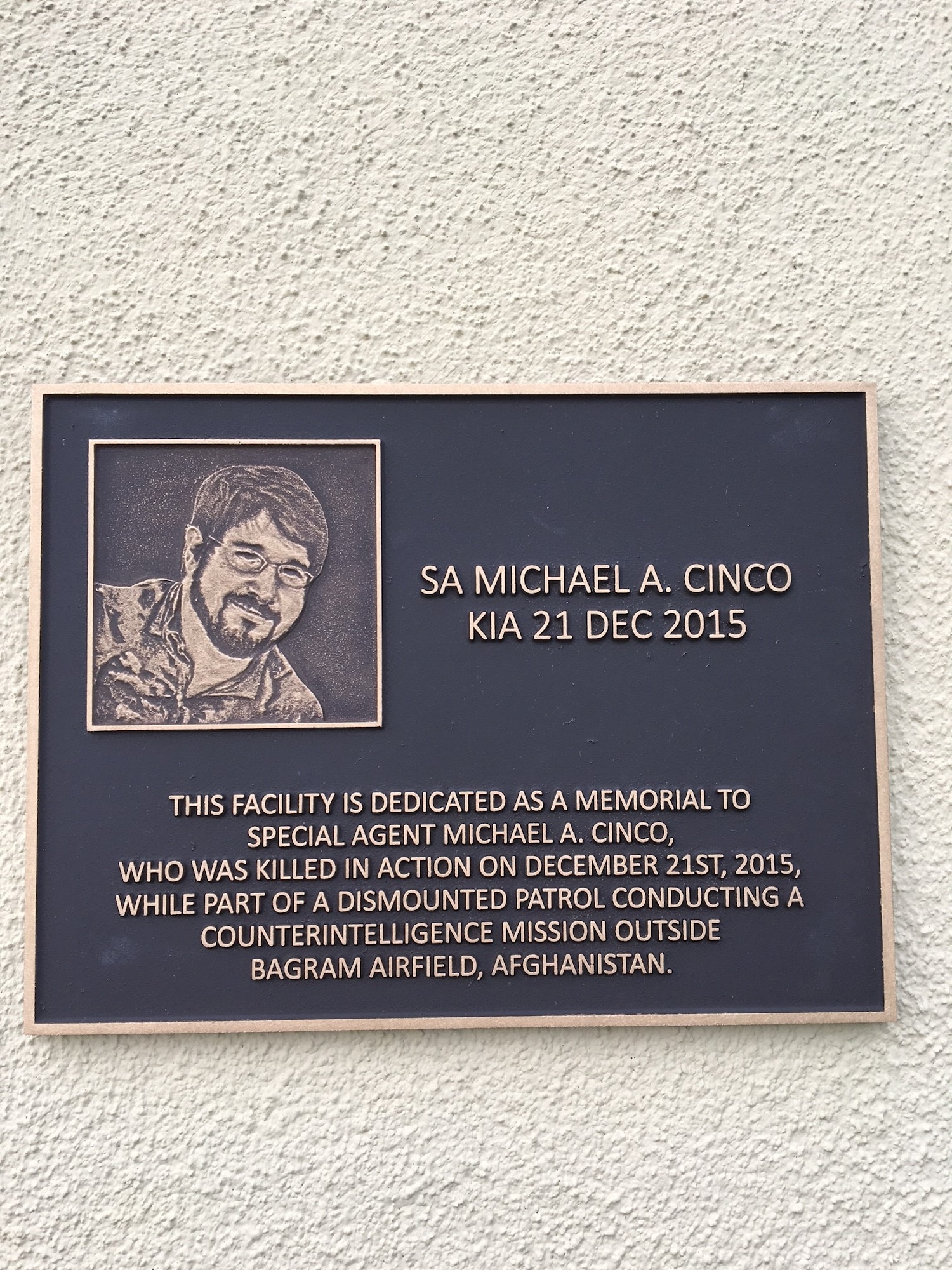 Visitors to the newly dedicated SA Michael A. Cinco Facility at Beale Air Force Base, Calif., are greeted at the entrance by the plaque stating when and how the Fallen Special Agent was killed in action Dec. 21, 2015, near Bagram Air Field, Afghanistan. (U.S. Air Force photo. Airman Tristan D. Viglianco 9 RW/PA)  