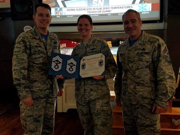 Col. Jeffrey Nelson, 437th Airlift Wing (AW) vice commander, left, and Chief Master Sgt. Kristopher Berg, 437th AW command chief, right, congratulate Senior Master Sgt. Emily Edmunds, 437th Operations Support Squadron superintendent, center, on her selection for chief master sergeant via the supplemental promotion process at Rookies here Dec. 16, 2016. Members are promoted through the supplemental process from testing out of their test cycle due to either extended temporary duty assignments or deployments.