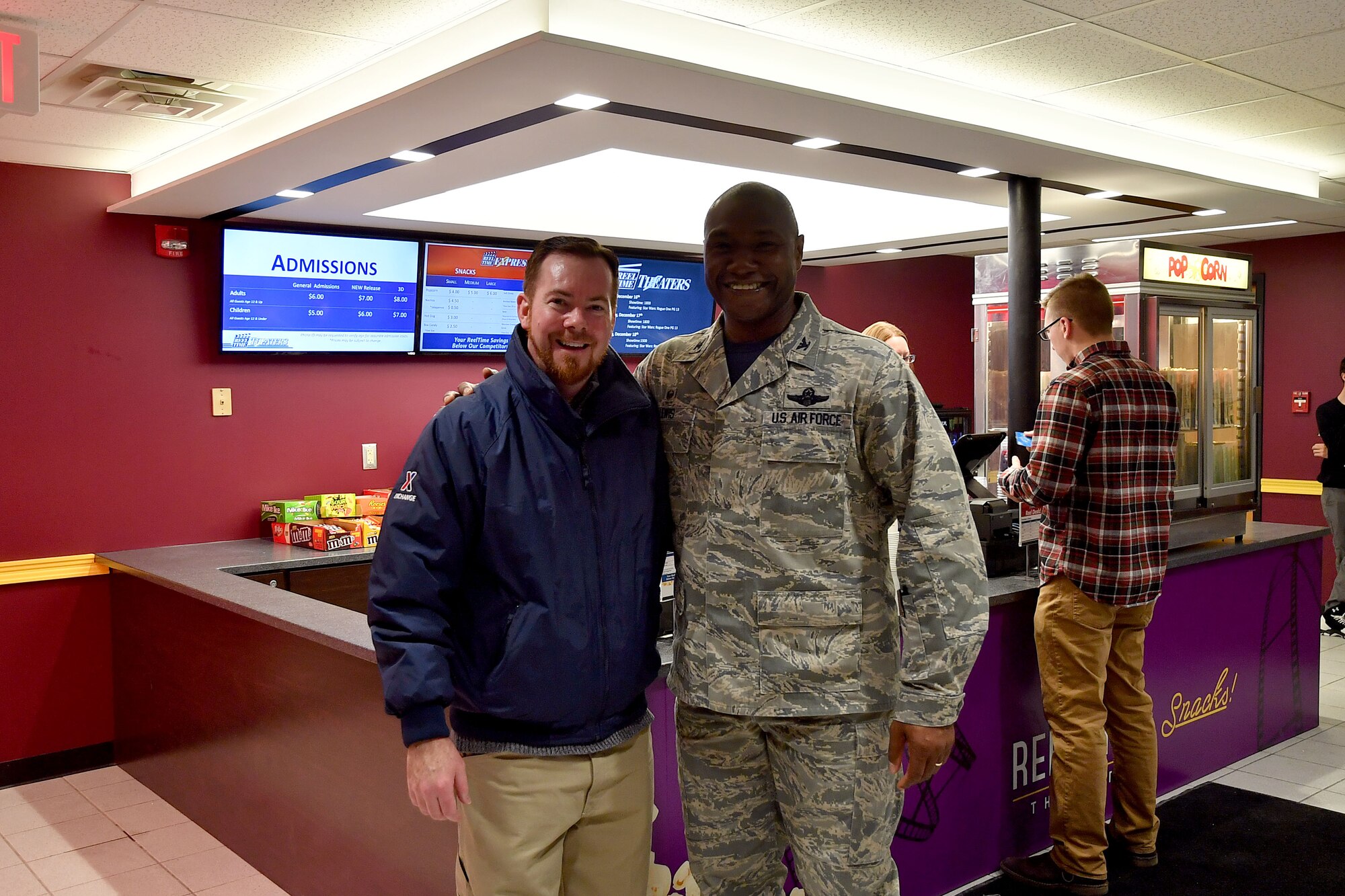 Col. Rodney Lewis, 319th Air Base Wing commander stands with George McNamara, Grand Forks Base Exchange general manager for a picture in the reopened theater on Grand Forks Air Force Base, N.D., Dec. 16; 2016. The renovation project for the theater was scheduled to take six months to complete, but the task was finished in four months. (U.S. Air Force photo by Airman 1st Class Elijaih Tiggs)