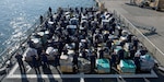 Members of the Coast Guard Cutter Hamilton crew stand next to approximately 26.5 tons of cocaine Dec. 15, 2016 aboard the cutter at Port Everglades Cruiseport in Fort Lauderdale, Florida. The crew of the Coast Guard Hamilton offloaded the cocaine in Port Everglades worth an estimated $715 million wholesale seized in international waters off the Eastern Pacific Ocean since Oct. 1, 2016. Coast Guard photo by Eric D. Woodall