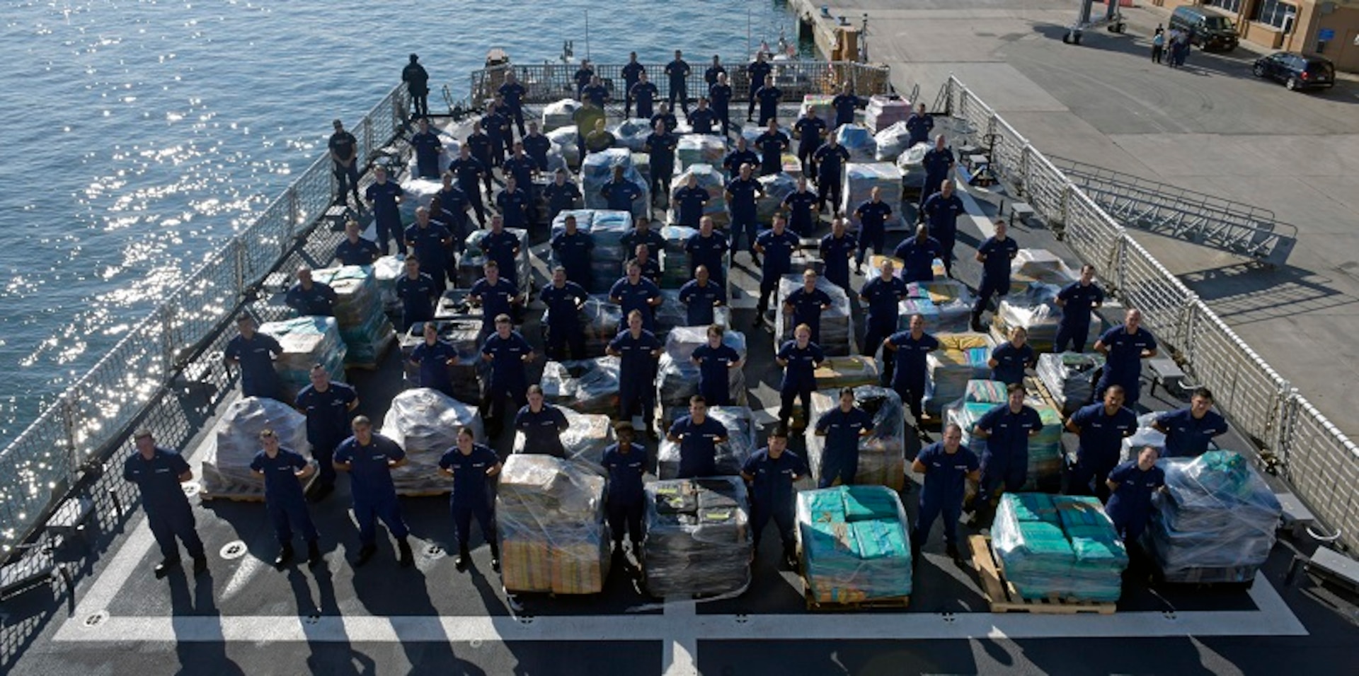 Members of the Coast Guard Cutter Hamilton crew stand next to approximately 26.5 tons of cocaine Dec. 15, 2016 aboard the cutter at Port Everglades Cruiseport in Fort Lauderdale, Florida. The crew of the Coast Guard Hamilton offloaded the cocaine in Port Everglades worth an estimated $715 million wholesale seized in international waters off the Eastern Pacific Ocean since Oct. 1, 2016. Coast Guard photo by Eric D. Woodall