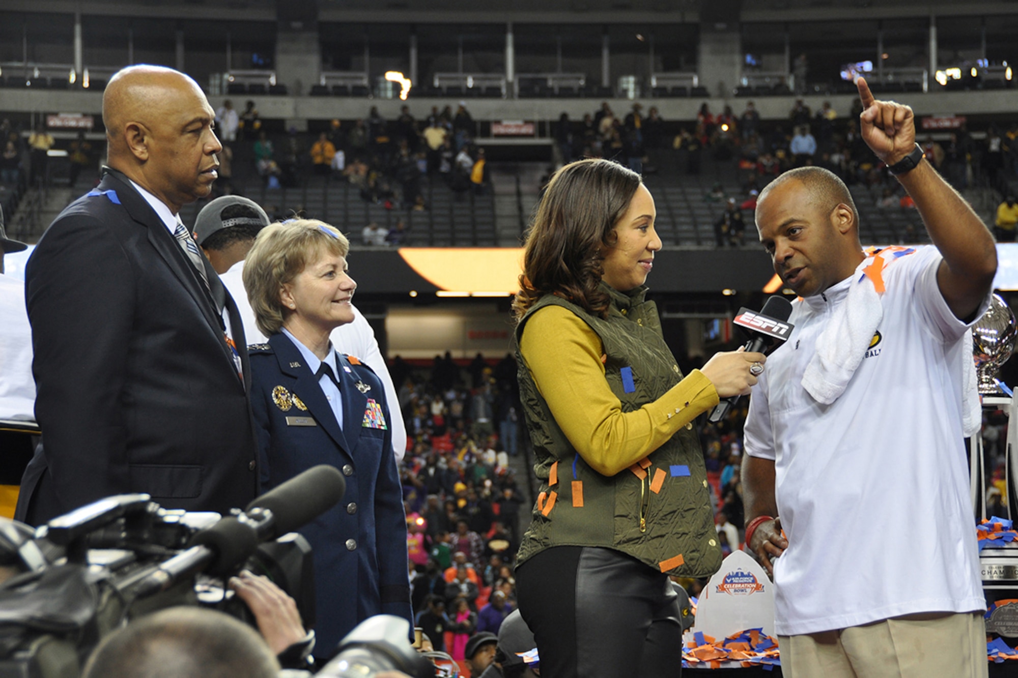 Lt. Gen. Maryanne Miller, chief of Air Force Reserve and commander of Air Force Reserve Command; John T. Grant, event executive director; and ESPN announcer Tiffany Greene congratulate Broderick Fobbs, Grambling State University head football coach, on his team winning the Air Force Reserve Celebration Bowl Dec. 17 at the Georgia Dome in Atlanta. (U.S. Air Force photo/Master Sgt. James Branch)