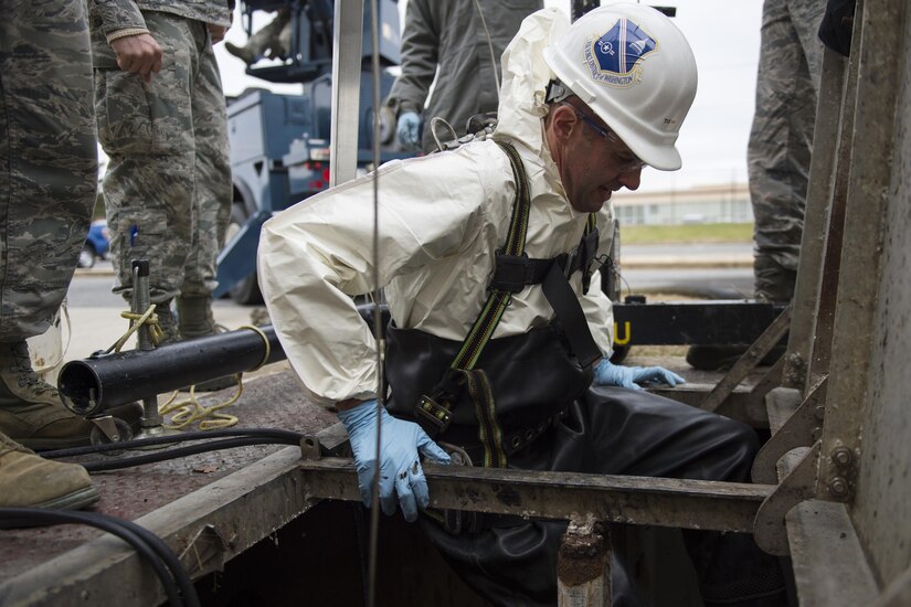 Col. E. John Teichert, 11th Wing and Joint Base Andrews commander, prepares to get into a sewage containment hole at Joint Base Andrews, Md., Dec. 13, 2016. Teichert assisted a 11th Civil Engineer Squadron water and fuel system maintenance member with replacing the lift station pumps on the east side of base. (U.S. Air Force photo by Senior Airman Philip Bryant)