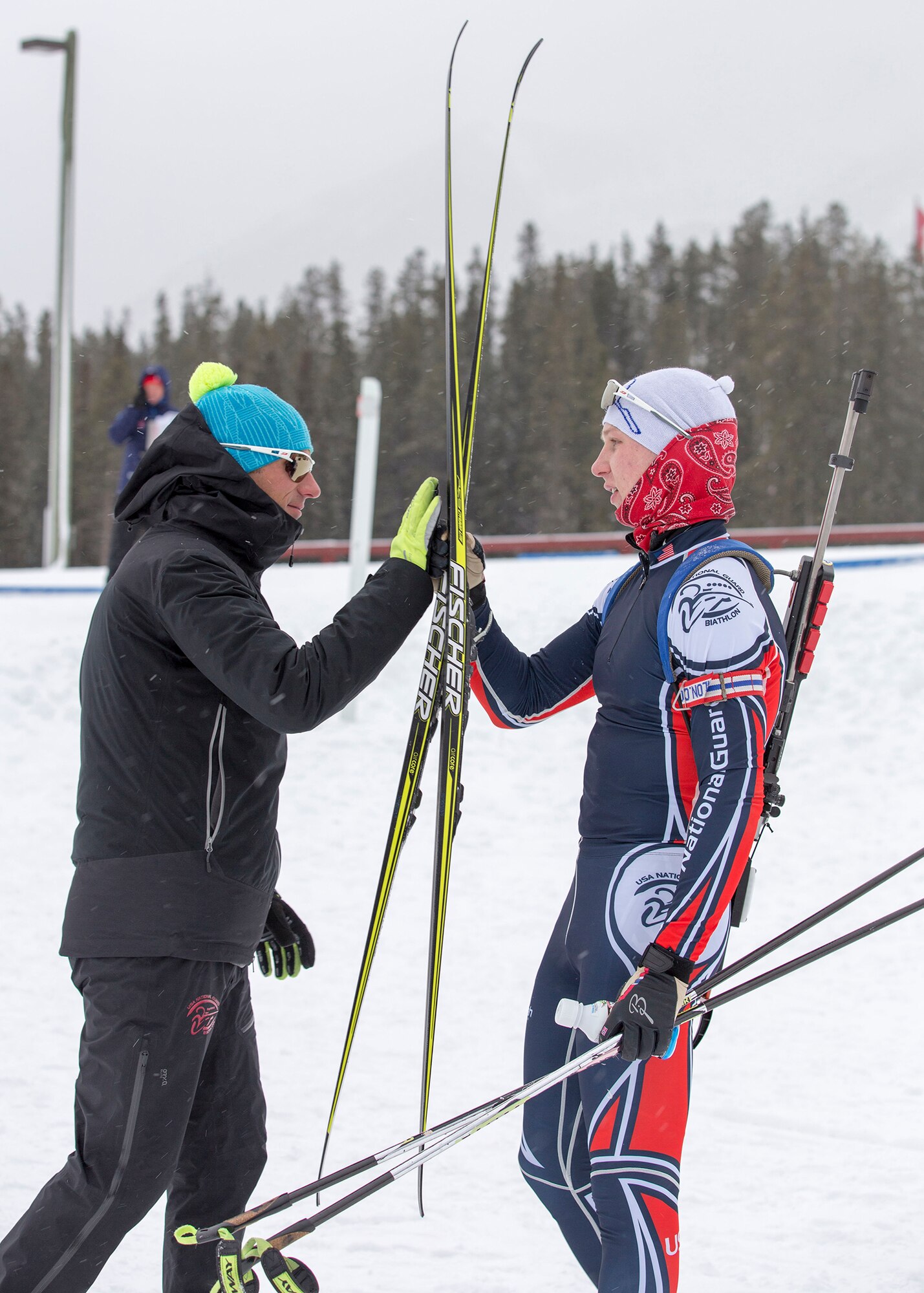 Alaska Army Guardsman Pfc. Travis Cooper, a construction equipment mechanic with the 207th Engineer Utility Detachment, gives a high-five to Vermont Air National Guardsman Tech. Sgt. Travis Voyer, an assistant coach with the National Guard Biathlon development team, after claiming his second gold in the junior men’s 12.5 km mass start in the North American #1 and Calforex #1 Biathlon Cups at the Canmore Nordic Centre Provincial Park in Canmore, Alberta, Dec. 4, 2016. Cooper, 20, of Kenai, also took first place in the junior men’s 10 km sprint the day before. Cooper trains year-round and competes on the National Guard Biathlon development team. (U.S. Army National Guard photo by Staff Sgt. Balinda O’Neal Dresel)