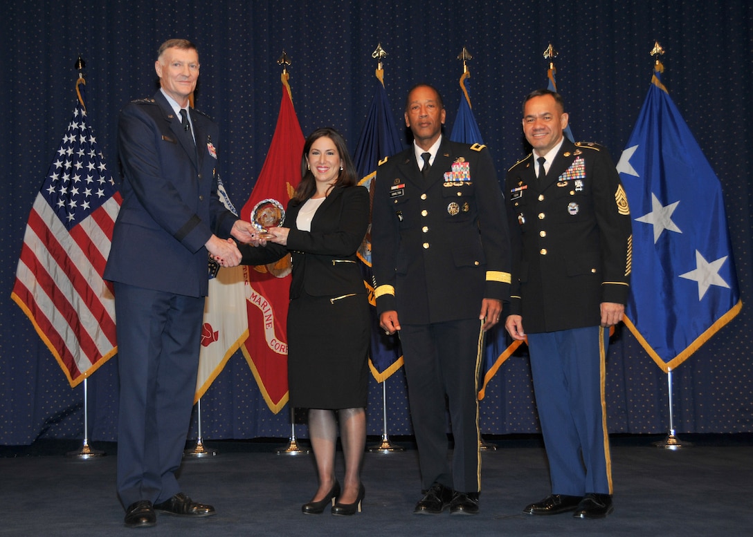 Director Air Force Lt. Gen. Andrew Busch presents Aysu Cesembasi as one of the Outstanding 10 DLA Personnel of the Year at the 49th Annual DLA Employee Recognition Award Ceremony Dec. 15 at DLA Headquarters. 
