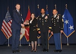 Director Air Force Lt. Gen. Andrew Busch presents Aysu Cesembasi as one of the Outstanding 10 DLA Personnel of the Year at the 49th Annual DLA Employee Recognition Award Ceremony Dec. 15 at DLA Headquarters. 
