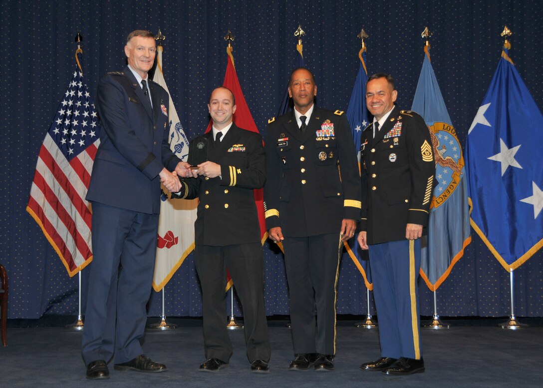 DLA Director Air Force Lt. Gen. Andrew Busch presents Navy Lt. Anthony Meyer, Subsistence, as DLA’s Company Grade Officer of the Year at the 49th Annual DLA Employee Recognition Award Ceremony Dec. 15 at DLA Headquarters. 