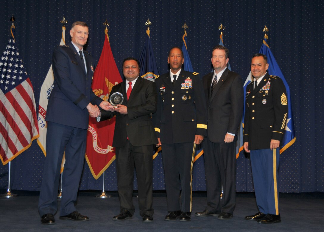 DLA Director Air Force Lt. Gen. Andrew Busch presents Kaushal Desai, Subsistence, with a DLA Leader of the Year award at the 49th Annual DLA Employee Recognition Award Ceremony Dec. 15 at DLA Headquarters.