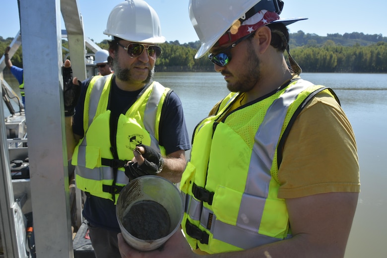 Researchers Anthony Priestas and Brandon Boyd from ERDC’s Coastal and Hydraulics Laboratory examine a core sample collected from the lab’s new coring barge on the Mississippi River near Vicksburg. 