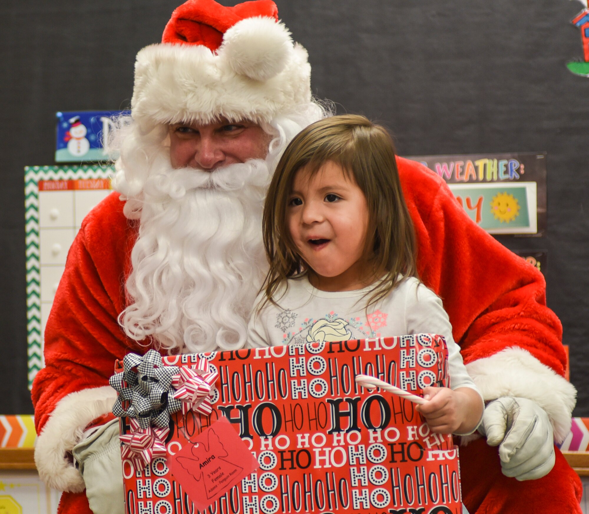 A child receives a present from Santa inside the Youth & Family Services center in Rapid City, S.D., Dec. 14, 2016. More than 250 children received a gift as part of this year’s Angel Tree program in Rapid City. (U.S. Air Force photo by Airman 1st Class Randahl J. Jenson)