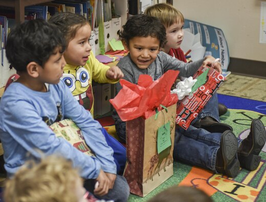 Children prepare to rip open their gifts inside the Youth & Family Services center in Rapid City, S.D., Dec. 14, 2016. Santa made a special appearance to hand-deliver presents to children at the Y&FS center during this year’s Angel Tree program. (U.S. Air Force photo by Airman 1st Class Randahl J. Jenson)