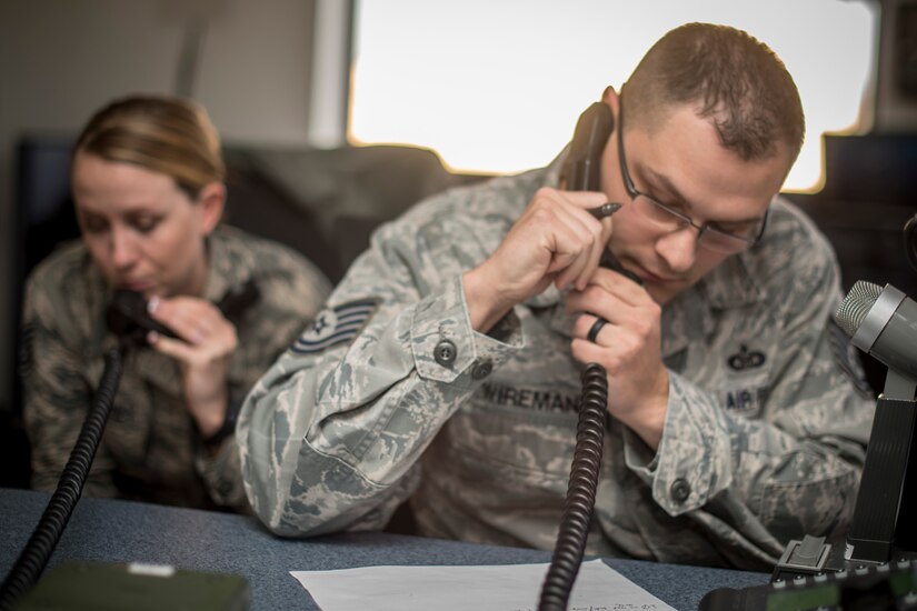 Tech Sgt. Jake Wireman, 1st Helicopter Squadron NCO in charge of console operations, and Tech. Sgt. Angeline Mahoney, 1st HS support flight chief and mission controller, relay information to the UH-1N Iroquois aircrews at Joint Base Andrews, Md., Dec. 7, 2016. Wireman and Mahoney are part of a team of nine Airmen that comprises the 1st HS mission control, following flights and relaying critical information to aircrews to complete their mission. The team was awarded the 2015 Small Unit Command Post of the Year based on excellence in mission accomplishment, performance and recognition of command post controllers, and training recognition. (U.S. Air Force photo by Airman 1st Class Rustie Kramer)