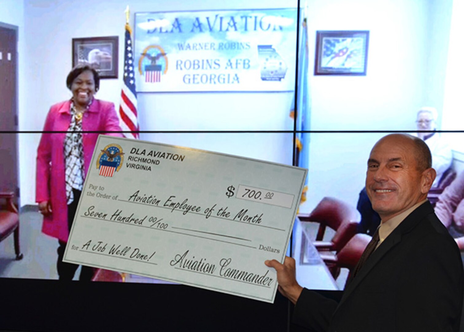 Defense Logistics Agency Aviation's employee Sheila Mills-Lugo was selected as the October Employee of the Month and is being presented the award check in a virtual presentation by DLA Aviation's Deputy Director Charlie Lilli on December 15, 2016 in a ceremony held in Richmond, Virginia.