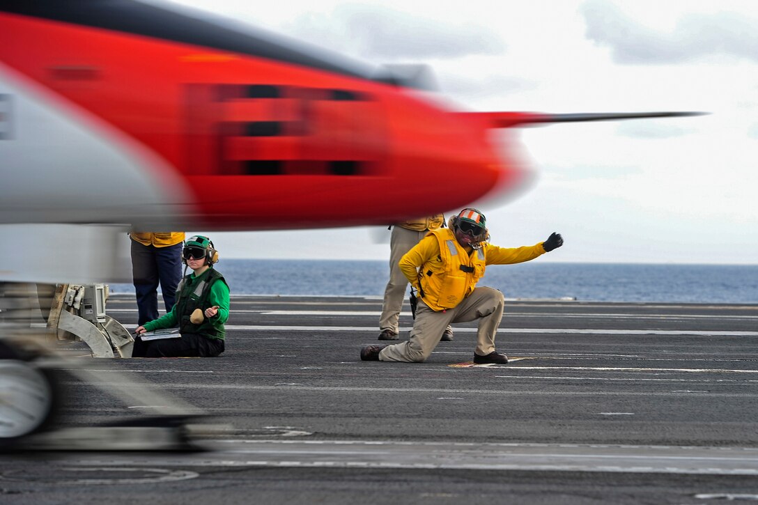 Lt. Jeffrey Knight, a shooter aboard the aircraft carrier USS George Washington, gives the signal to launch a T-45C Goshawk from the flight deck during carrier qualifications in the Atlantic Ocean, Dec. 12, 2016.  Navy photo by Petty Officer 3rd Class Wyatt L. Anthony