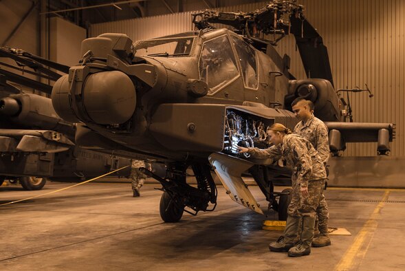 An Airman from the 821st Contingency Response Squadron, and a Soldier from the 1st Attack Reconnaissance Battalion, 25th Combat Aviation Brigade performs a joint inspection on an AH-64 Apache helicopter before it’s loaded onto a C-17 Globemaster III Dec. 11, 2016, at Eielson Air Force Base, Alaska. A contingency response team was sent to Eielson AFB to support the Army’s Rapid Alaska Airlift Week exercise. (U.S. Air Force photo/Staff Sgt. Robert Hicks)