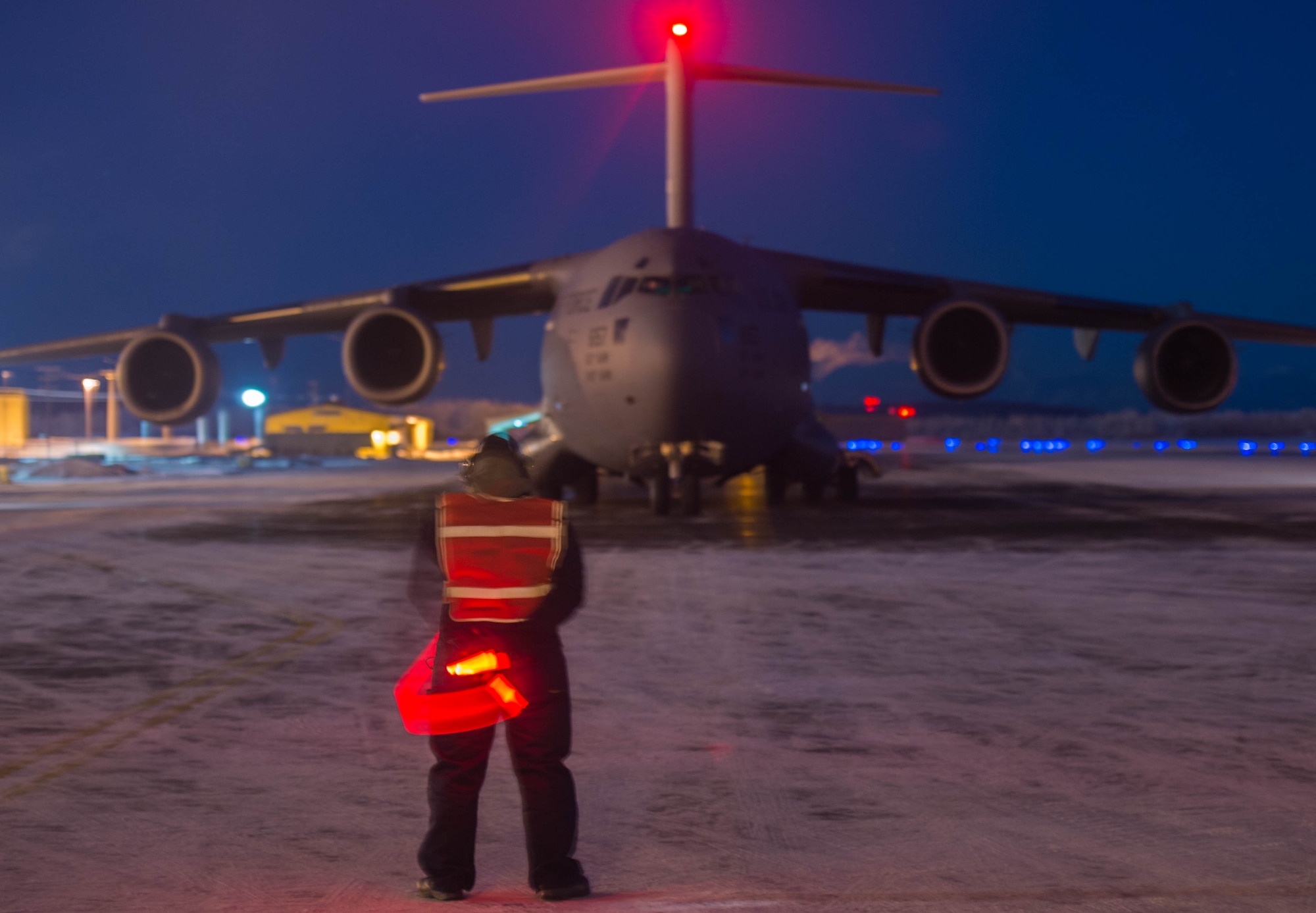 Staff Sgt. Justin Fraissinet, 821st Contingency Response Squadron maintainer, prepares to marshal a C-17 Globemaster III aircraft, Dec. 12, 2016, at Eielson Air Force Base, Alaska. A contingency response team was sent to Eielson AFB to support the Army’s Rapid Alaska Airlift Week exercise. (U.S. Air Force photo by Staff Sgt. Robert Hicks)