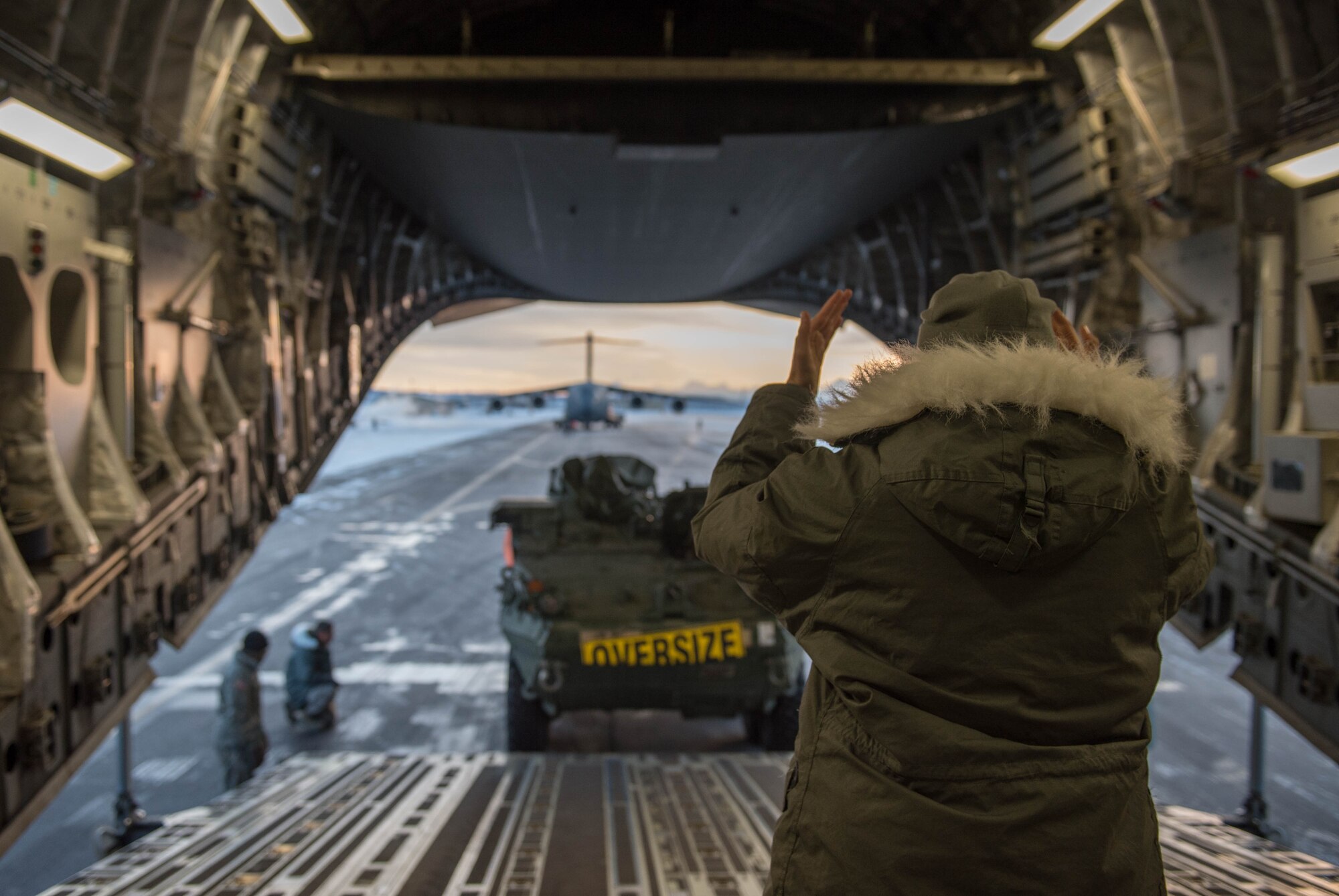 Airman 1st Class Kaitlyn Besse, 21st Airlift Squadron, guides a Stryker armored vehicle from the 1st Battalion, 24th Infantry Regiment, 1st Stryker Brigade Combat Team, 25th Infantry Division, onto a C-17 Globemaster III aircraft, Dec. 13, 2016, at Eielson Air Force Base, Alaska. A contingency response team was sent to Eielson AFB to support the Army’s Rapid Alaska Airlift Week exercise. (U.S. Air Force photo by Staff Sgt. Robert Hicks)