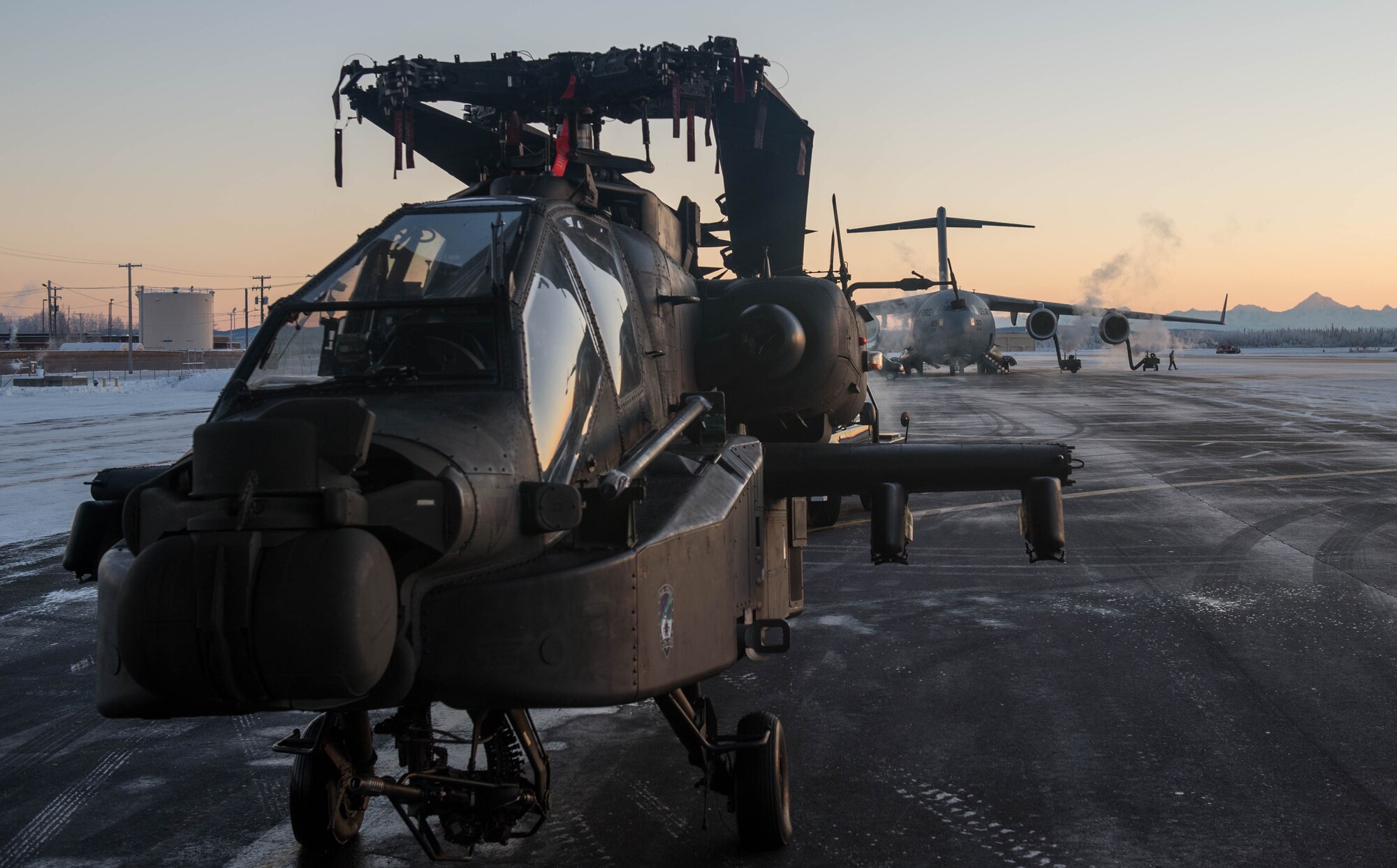 An AH-64 Apache helicopter from the 1st Attack Reconnaissance Battalion, 25th Combat Aviation Brigade, sits on the flightline waiting to be loaded onto a C-17 Globemaster III aircraft, Dec.14, 2016, at Eielson Air Force Base, Alaska. A contingency response team was sent to Eielson AFB to support the Army’s Rapid Alaska Airlift Week exercise. (U.S. Air Force photo by Staff Sgt. Robert Hicks)