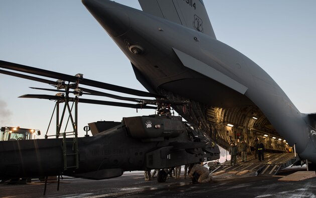 An AH-64 Apache helicopter from the 1st Attack Reconnaissance Battalion, 25th Combat Aviation Brigade is loaded onto a C-17 Globemaster III Dec.14, 2016, at Eielson Air Force Base, Alaska. A contingency response team was sent to Eielson AFB to support the Army’s Rapid Alaska Airlift Week exercise. (U.S. Air Force photo/Staff Sgt. Robert Hicks)