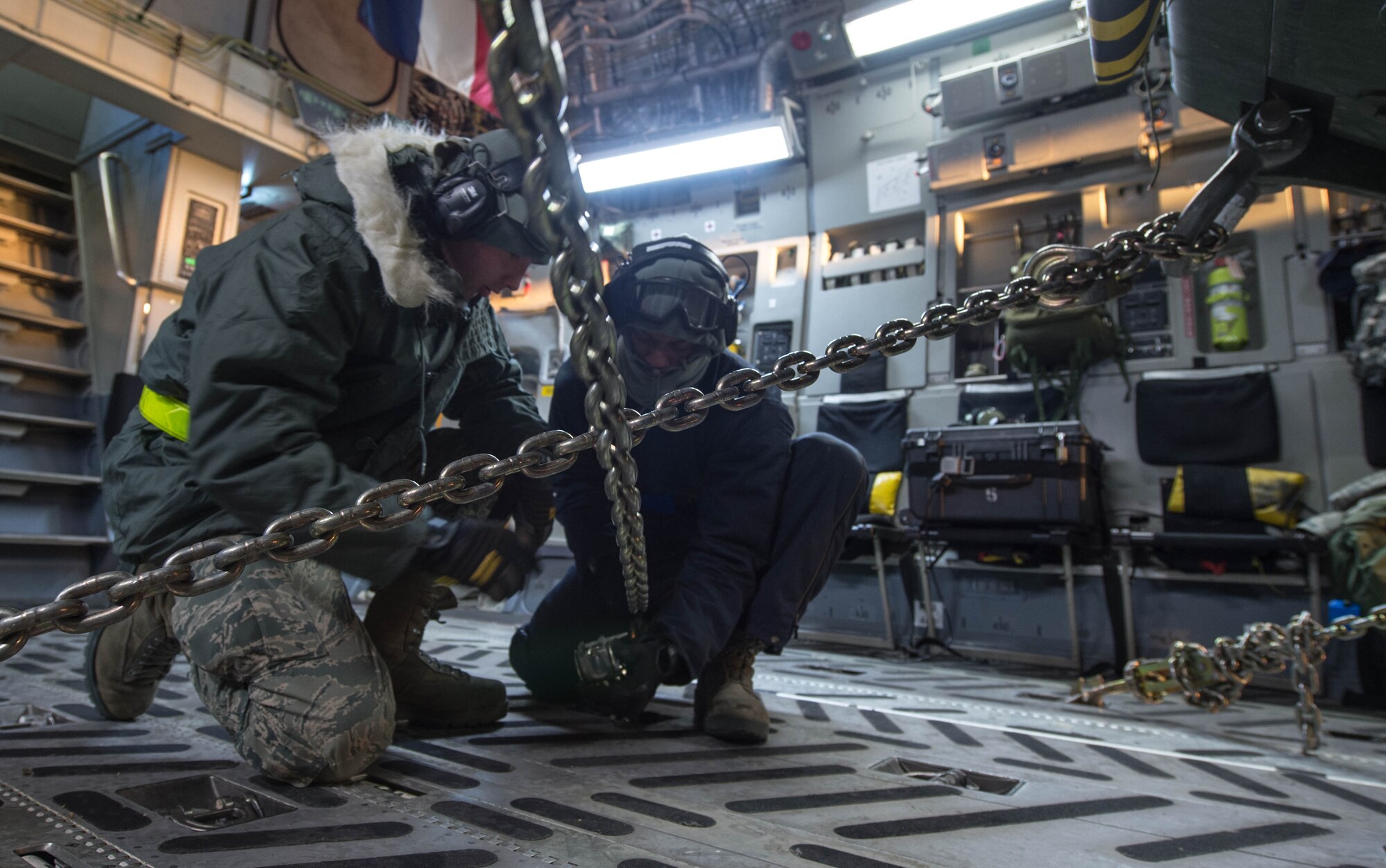 Senior Airman Joshua Martin, left, and Airman 1st Class Elijah Roberts from the 821st Contingency Response Group, strap down a Stryker armored vehicle from the 1st Battalion, 24th Infantry Regiment, 1st Stryker Brigade Combat Team, 25th Infantry Division, onto a C-17 Globemaster III Dec.14, 2016, at Eielson Air Force Base, Alaska. A contingency response team was sent to Eielson AFB to support the Army’s Rapid Alaska Airlift Week exercise. (U.S. Air Force photo by Staff Sgt. Robert Hicks)  
