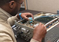 Airman 1st Class Terre Camille, an avionics technician assigned to the 28th Maintenance Squadron, installs an amp into a Line Replaceable Unit at Ellsworth Air Force Base, S.D., Dec. 6, 2016. An LRU is a modular component of complex electronic systems for aircraft that can be replaced quickly, and generally with a minimum of tools. (U.S. Air Force photo by Airman 1st Class Donald C. Knechtel)