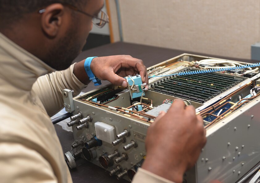 Airman 1st Class Terre Camille, an avionics technician assigned to the 28th Maintenance Squadron, installs an amp into a Line Replaceable Unit at Ellsworth Air Force Base, S.D., Dec. 6, 2016. An LRU is a modular component of complex electronic systems for aircraft that can be replaced quickly, and generally with a minimum of tools. (U.S. Air Force photo by Airman 1st Class Donald C. Knechtel)