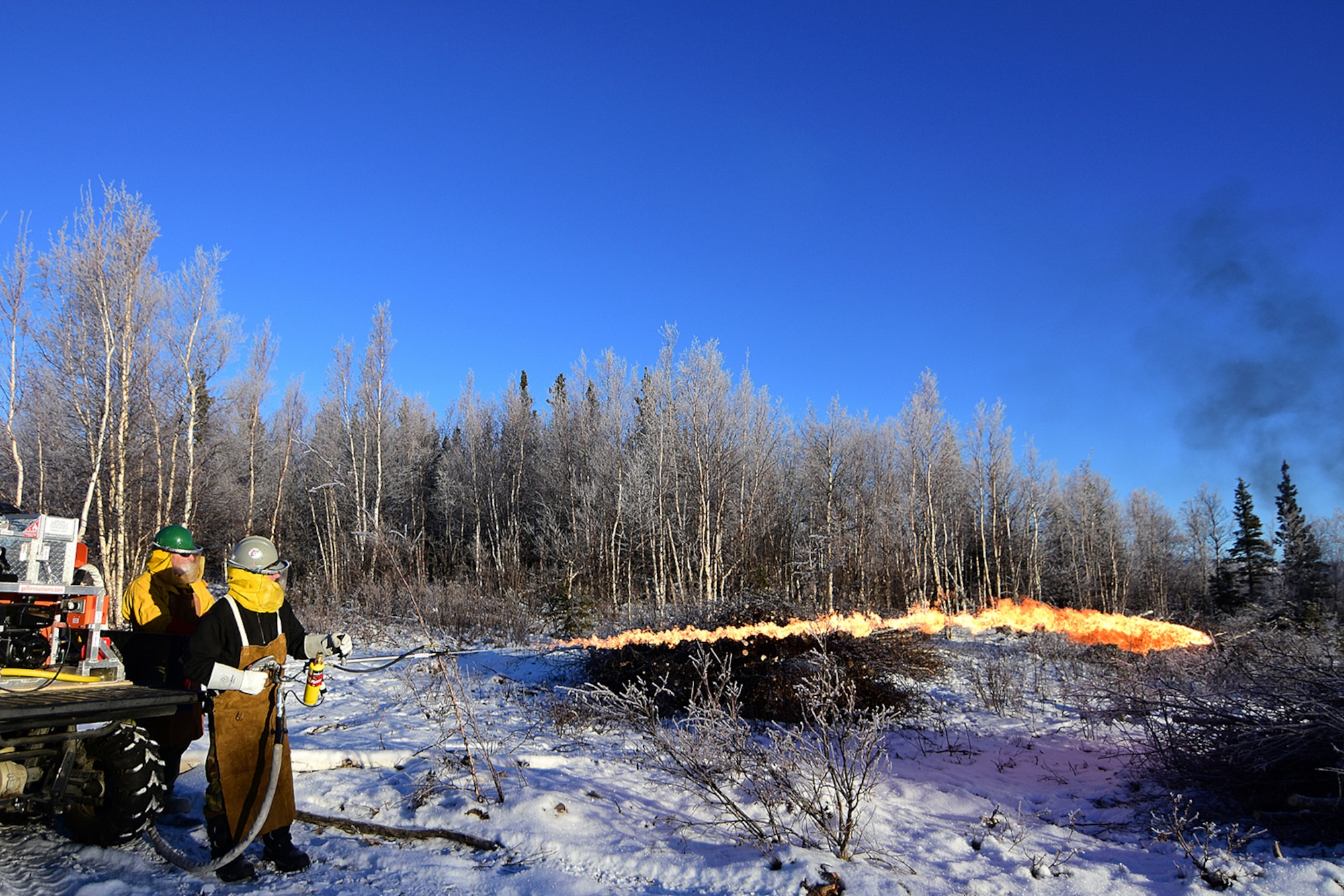 Bureau of Land Management Bureau of Land Management Alaska Fire Service specialist Matt Kilgriff shoots a stream of flaming gel from the Terra Torch to burn piles of brush and trees as part of a prescribed burn project in U.S. Army Alaska’s Donnelly Training Area near Fort Greely Nov. 4, 2016. The piles were created by U.S. Army Alaska hand crews working to remove dead and decaying vegetation and black spruce in an effort to reduce the chances of a wildfire on military lands. AFS provides wildland fire management for 1.6 million acres of military withdrawn public land under an interagency service agreement with U.S. Army Alaska. (Army photo/John Pennell)