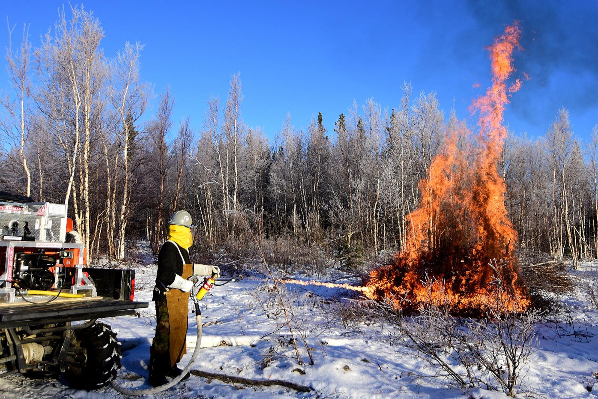 Bureau of Land Management Bureau of Land Management Alaska Fire Service specialist Matt Kilgriff shoots a stream of flaming gel from the Terra Torch to burn piles of brush and trees as part of a prescribed burn project in U.S. Army Alaska’s Donnelly Training Area near Fort Greely Nov. 4, 2016. The piles were created by U.S. Army Alaska hand crews working to remove dead and decaying vegetation and black spruce in an effort to reduce the chances of a wildfire on military lands. AFS provides wildland fire management for 1.6 million acres of military withdrawn public land under an interagency service agreement with U.S. Army Alaska. (Army photo/John Pennell)