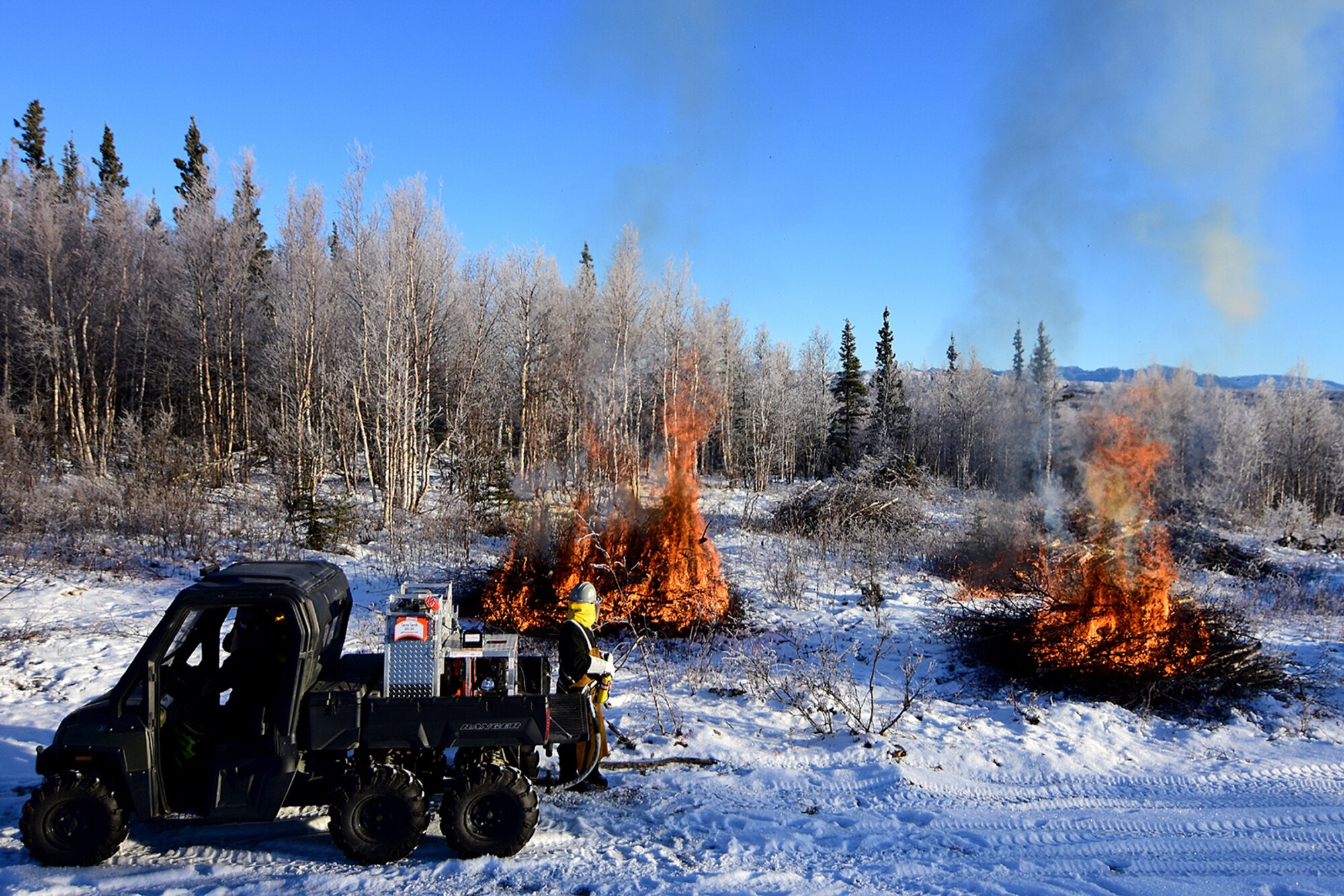 Bureau of Land Management Bureau of Land Management Alaska Fire Service specialist Matt Kilgriff shoots a stream of flaming gel from the Terra Torch to burn piles of brush and trees as part of a prescribed burn project in U.S. Army Alaska’s Donnelly Training Area near Fort Greely Nov. 4, 2016. The piles were created by U.S. Army Alaska hand crews working to remove dead and decaying vegetation and black spruce in an effort to reduce the chances of a wildfire on military lands. AFS provides wildland fire management for 1.6 million acres of military withdrawn public land under an interagency service agreement with U.S. Army Alaska. (Army photo/John Pennell)