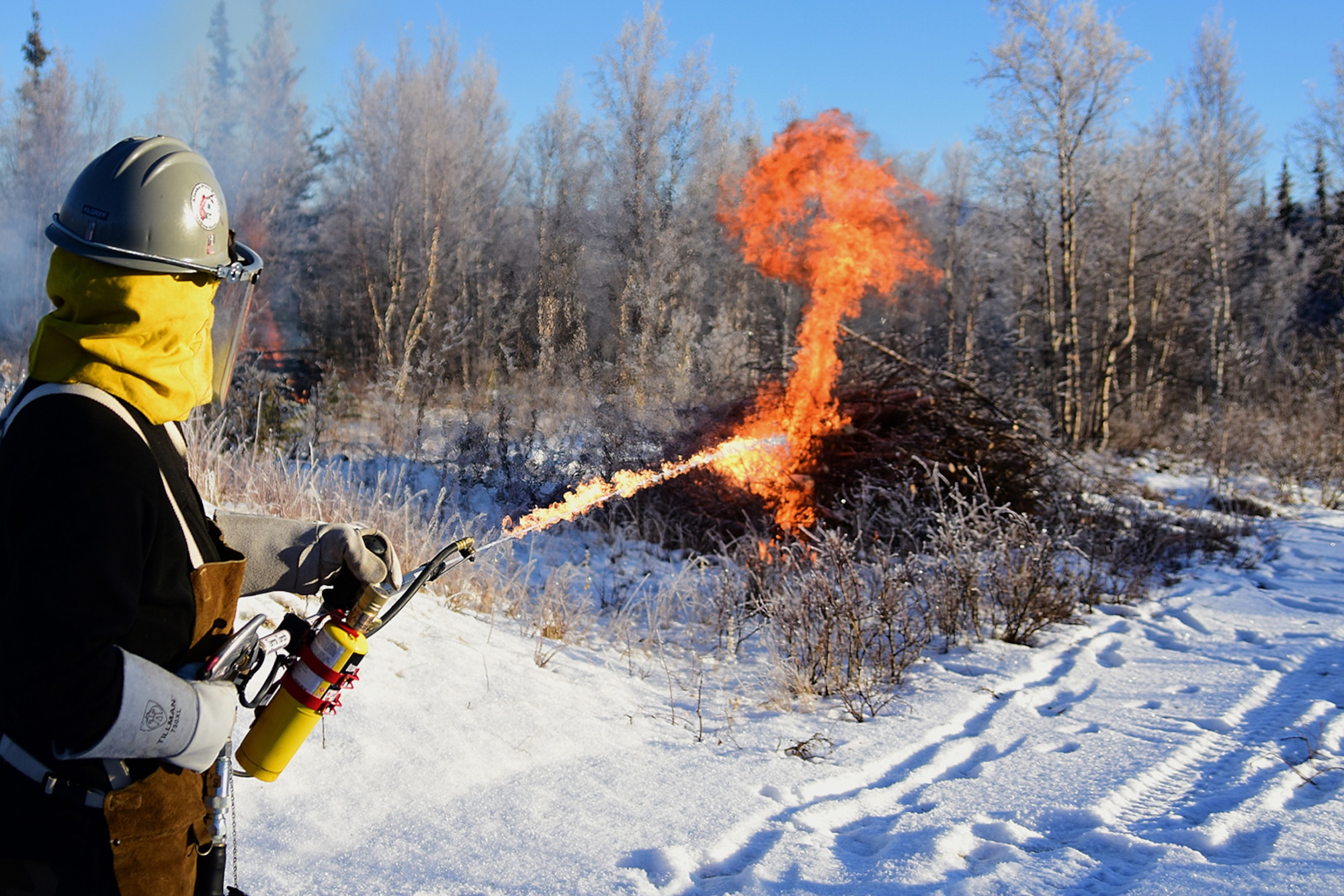 Bureau of Land Management Bureau of Land Management Alaska Fire Service specialist Matt Kilgriff shoots a stream of flaming gel from the Terra Torch to burn piles of brush and trees as part of a prescribed burn project in U.S. Army Alaska’s Donnelly Training Area near Fort Greely Nov. 4, 2016. The piles were created by U.S. Army Alaska hand crews working to remove dead and decaying vegetation and black spruce in an effort to reduce the chances of a wildfire on military lands. AFS provides wildland fire management for 1.6 million acres of military withdrawn public land under an interagency service agreement with U.S. Army Alaska. (Army photo/John Pennell)